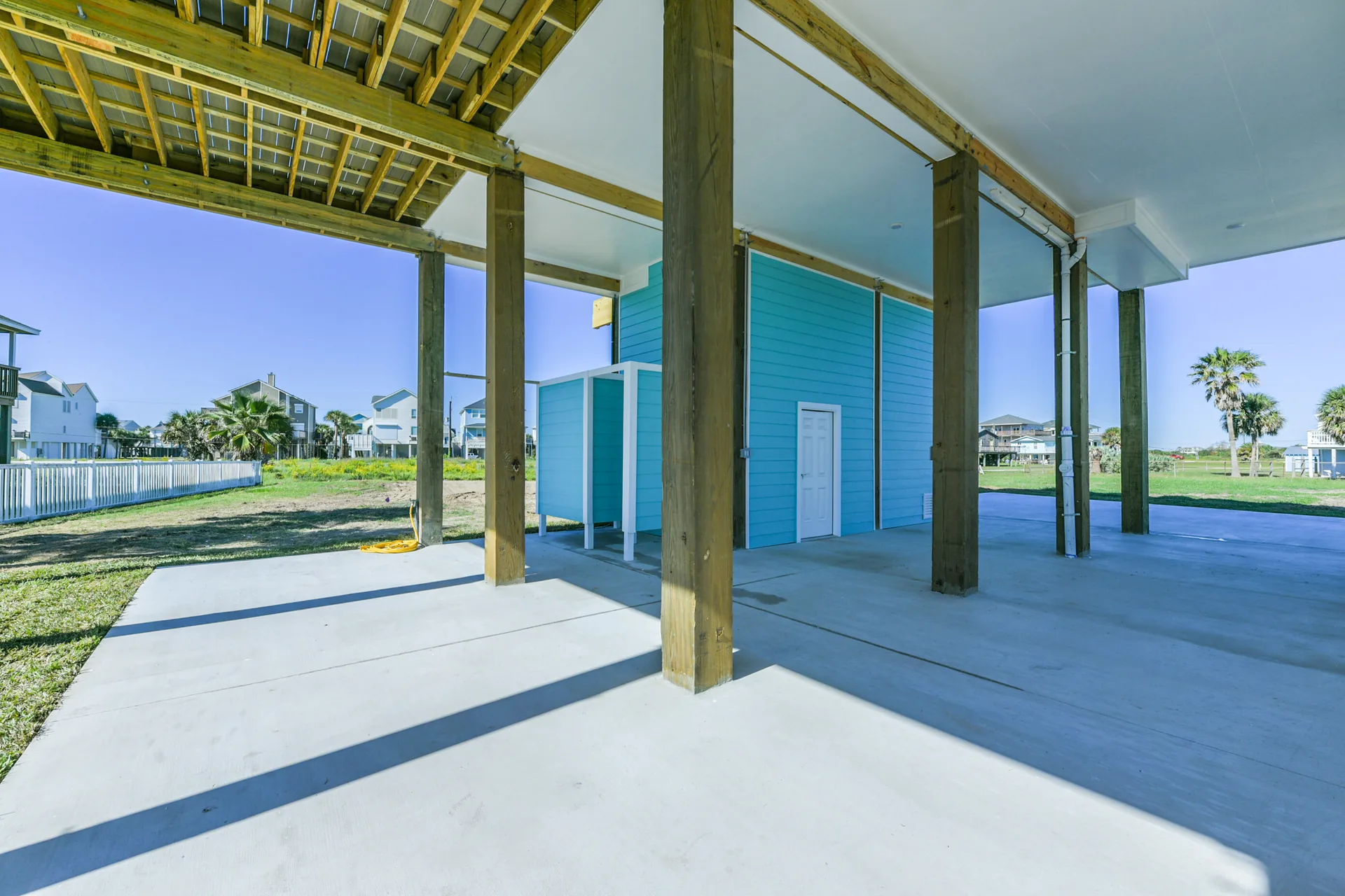 Ground-level covered deck at 11 Mile with timber posts, painted decking, and open views to the water