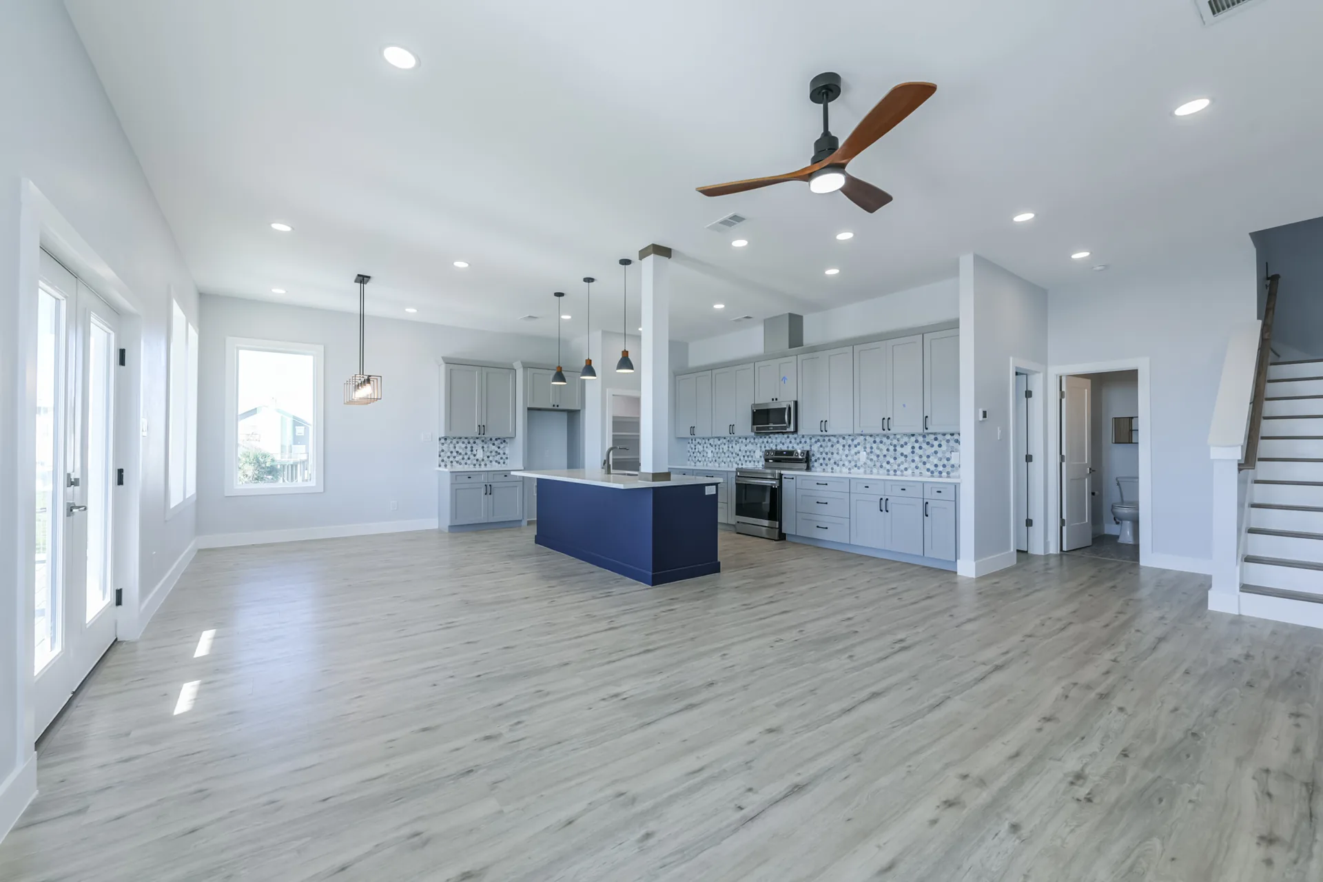 Wide kitchen view at 11 Mile including the staircase and the run of white shaker cabinetry