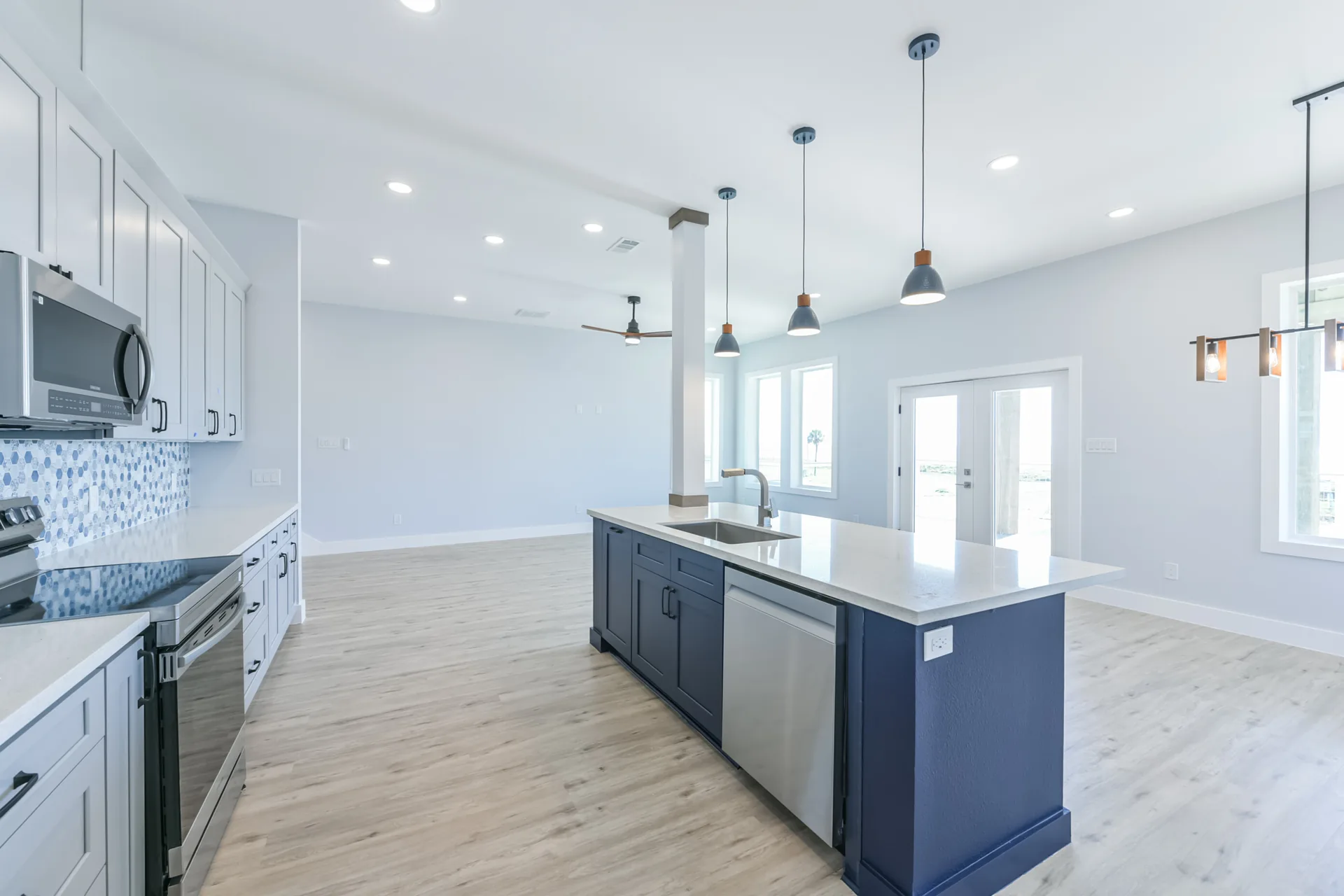 Wide view of the 11 Mile kitchen showing the range wall, island, and adjacent living space