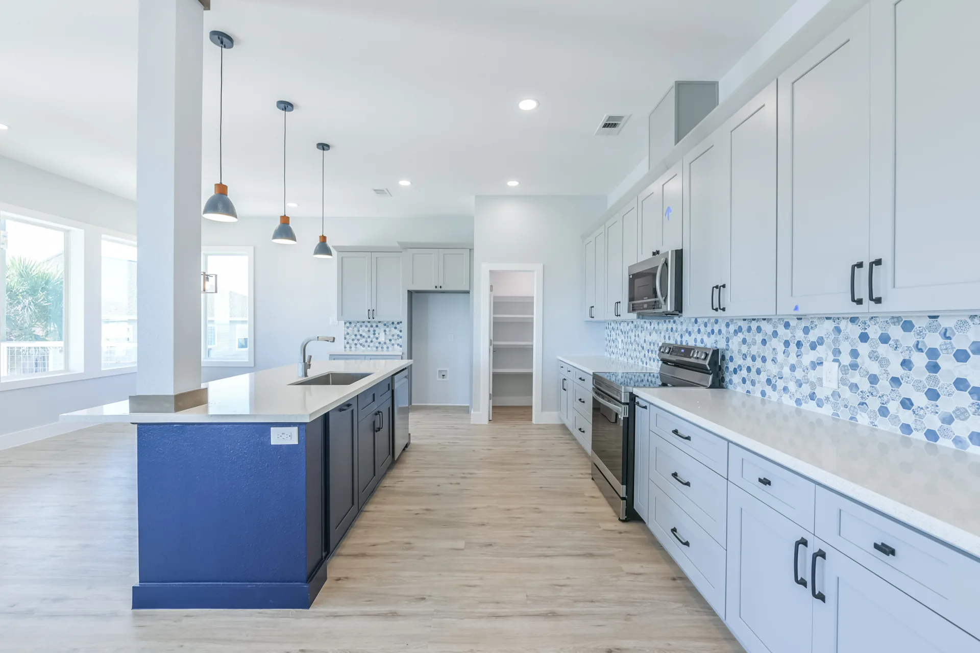 Kitchen at 11 Mile with walk-in pantry door, stainless appliances, and quartz counters
