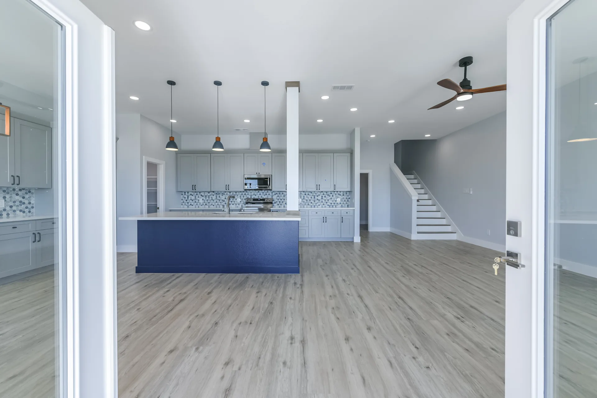 View into the 11 Mile kitchen from the entry, framed by cased openings and the staircase beyond