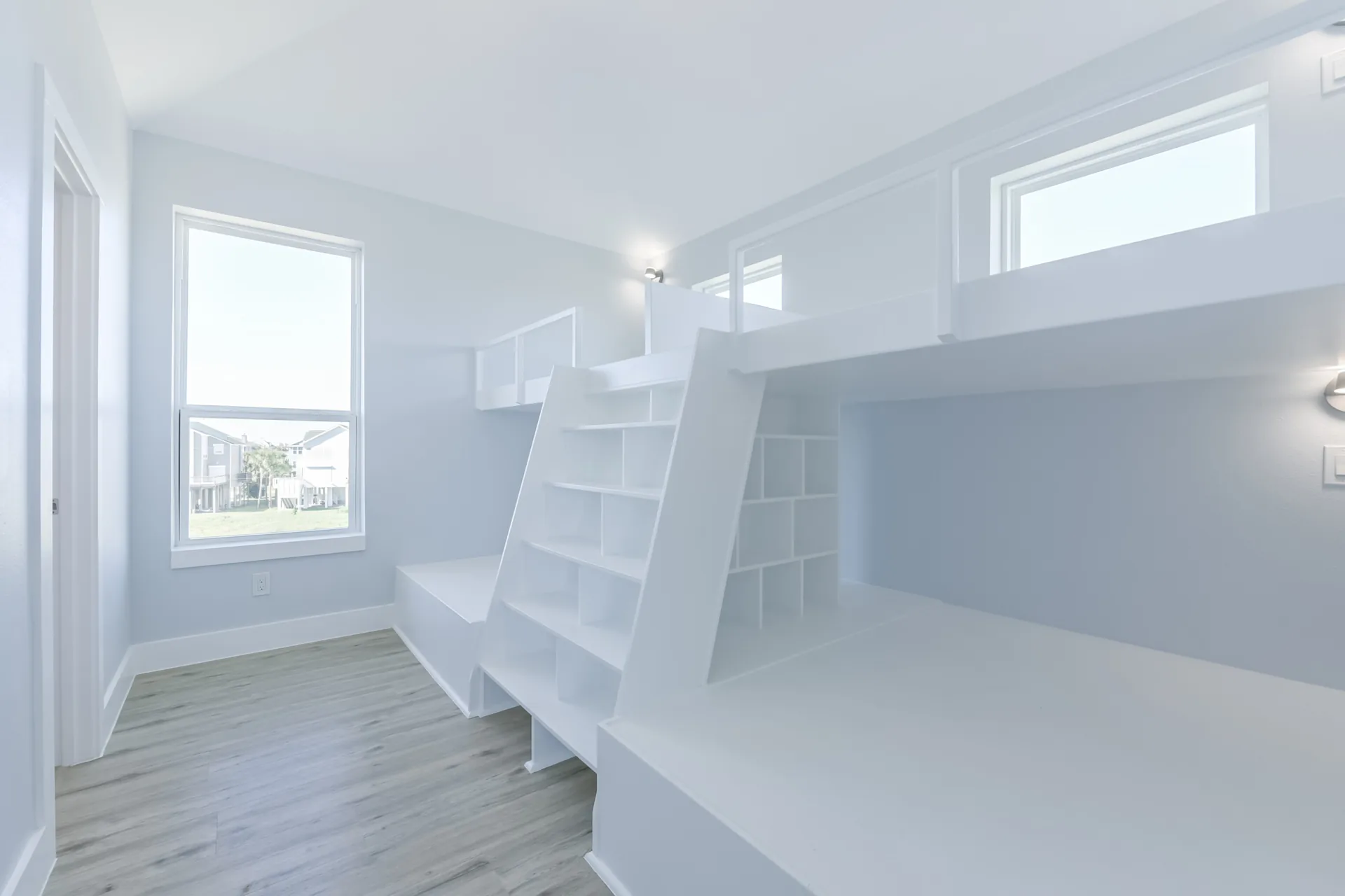 Built-in bunk room at 11 Mile with custom white bunks, integrated ladder, and window seating