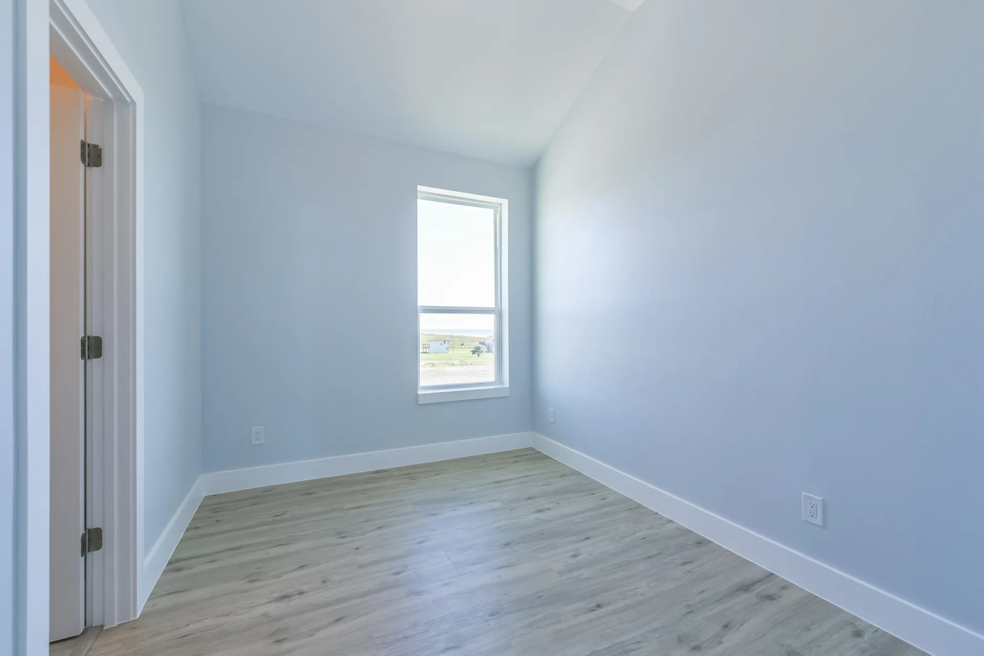 Bedroom at 11 Mile with vaulted ceiling detail and natural light from a corner window