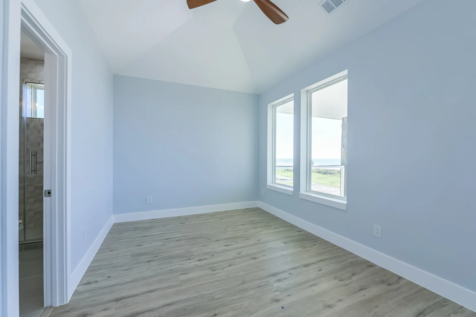 Corner bedroom at 11 Mile with windows on two walls and views across the prairie