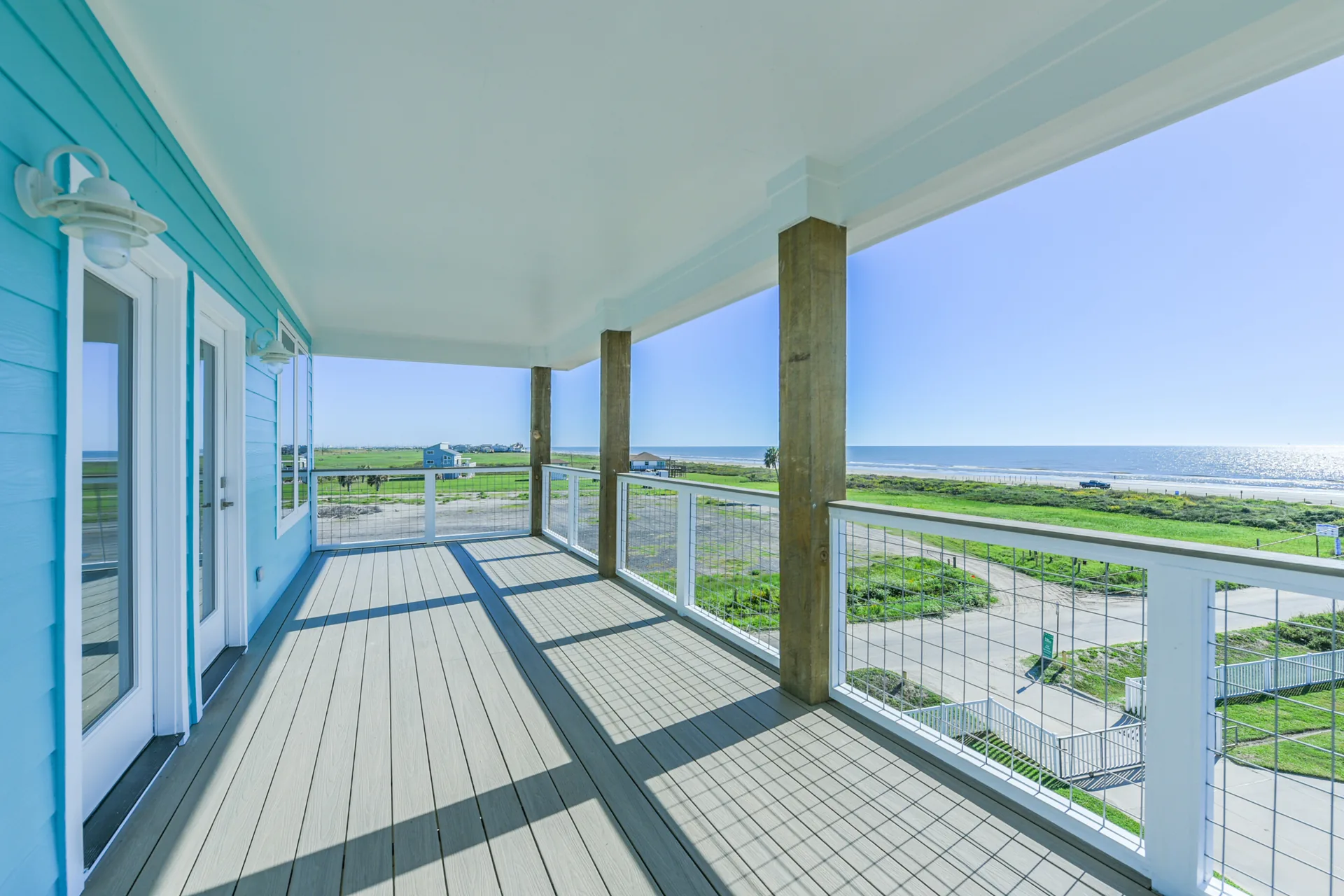 Corner of the 11 Mile wraparound deck with turquoise siding, white trim, and cable rail detail