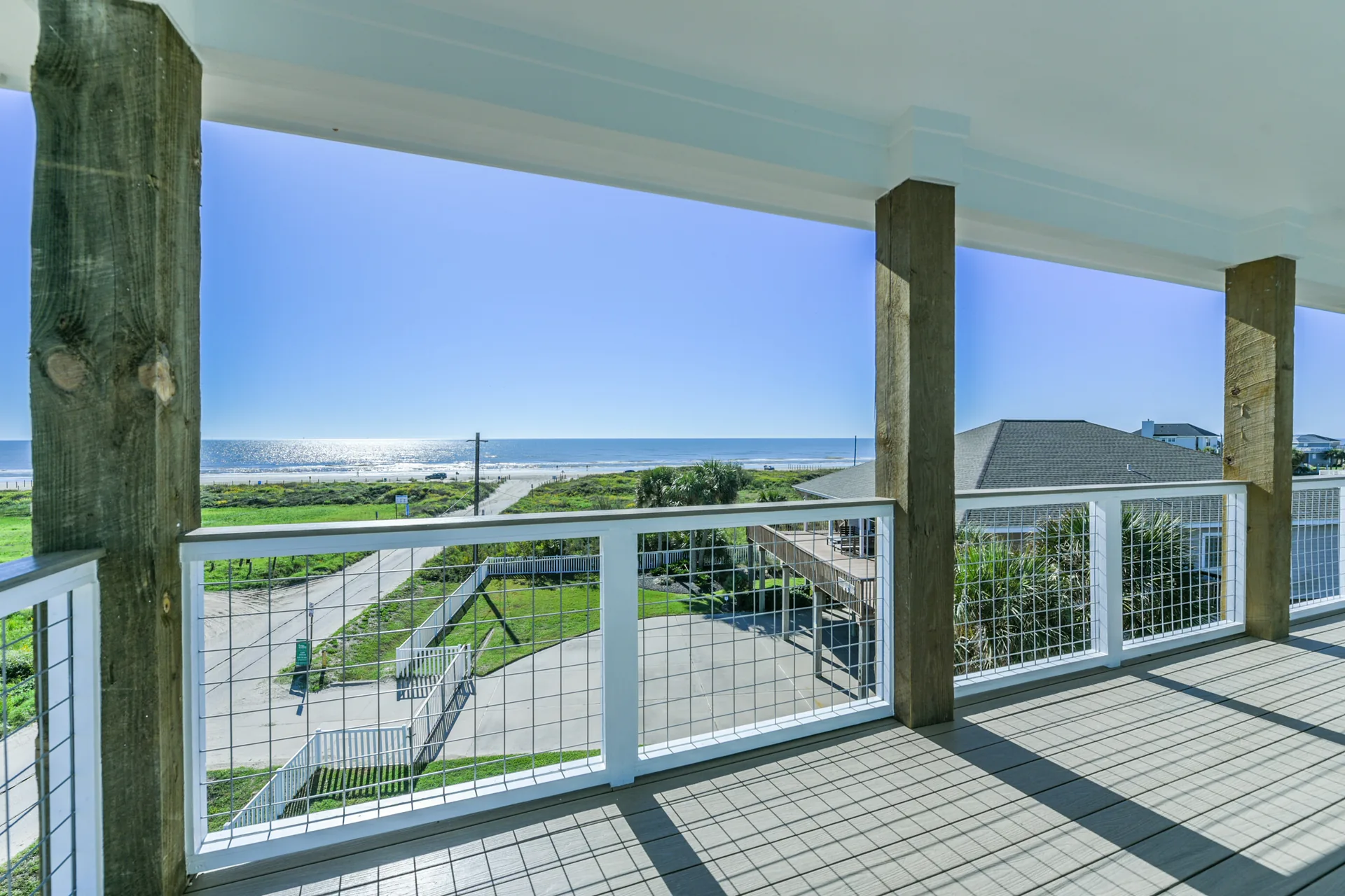 Covered deck at 11 Mile with exposed structural posts and cable railing overlooking the coastal prairie
