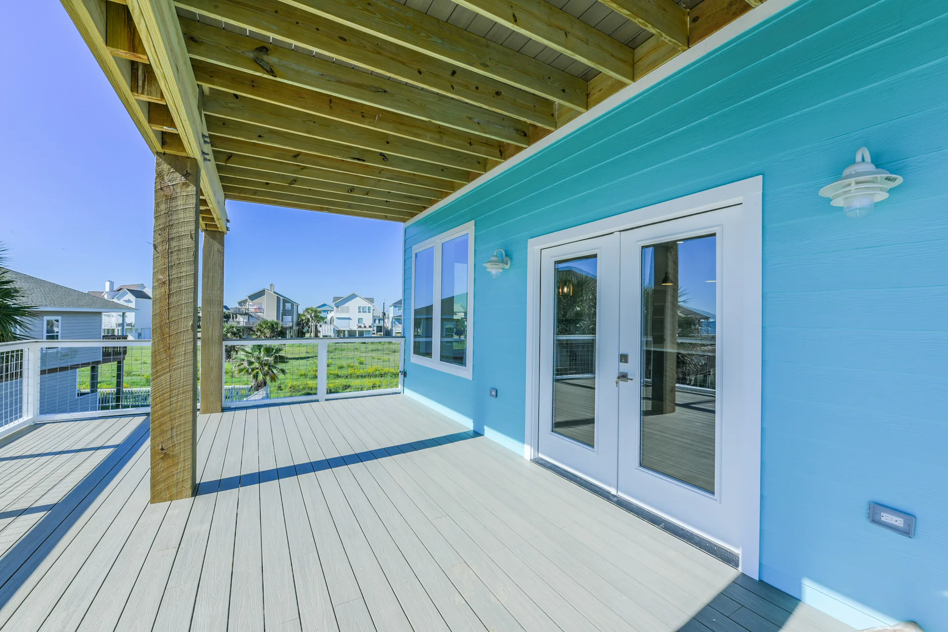 Deck at 11 Mile with French doors opening into the living space and a nautical wall light