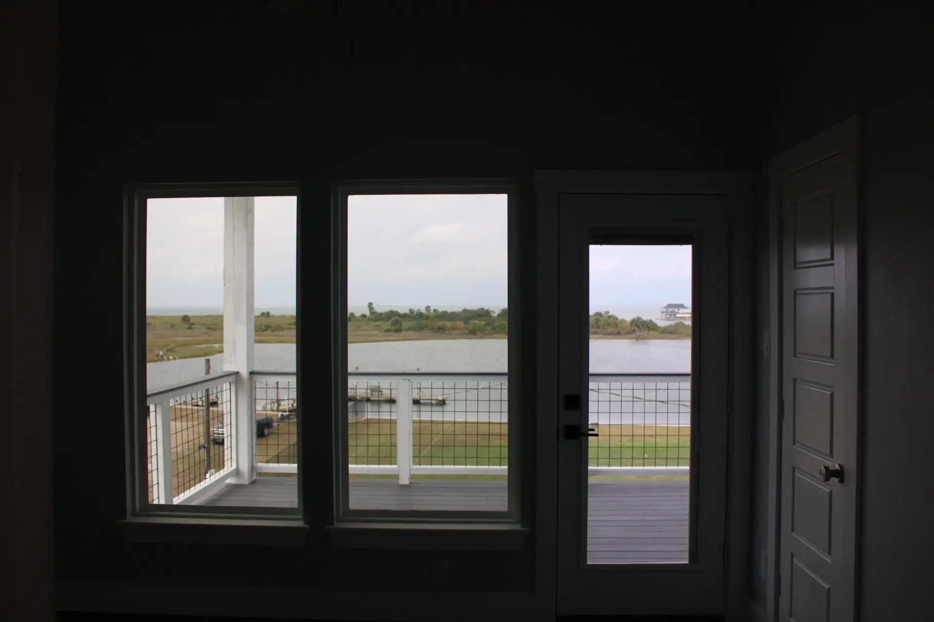 Kitchen area with white cabinetry, modern countertops, and pendant lighting over the island with dark wood-look flooring extending throughout