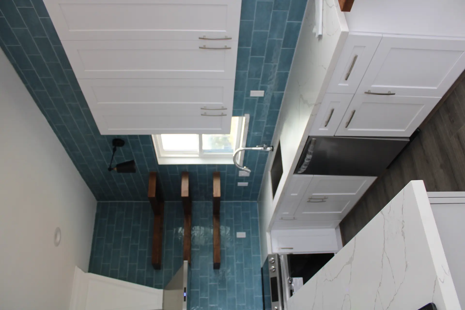 Primary bathroom with large marble-look tile shower, frameless glass enclosure, modern chrome fixtures, and decorative tile floor accent pattern