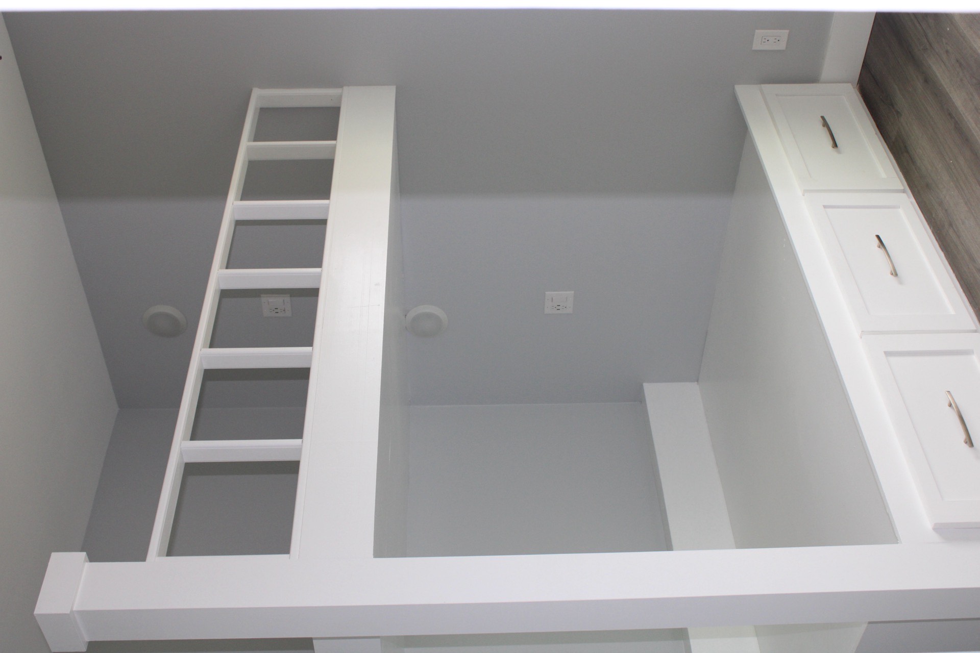 Primary shower interior showing floor-to-ceiling marble-look wall tile, recessed niche shelf, and frameless glass door with chrome hardware