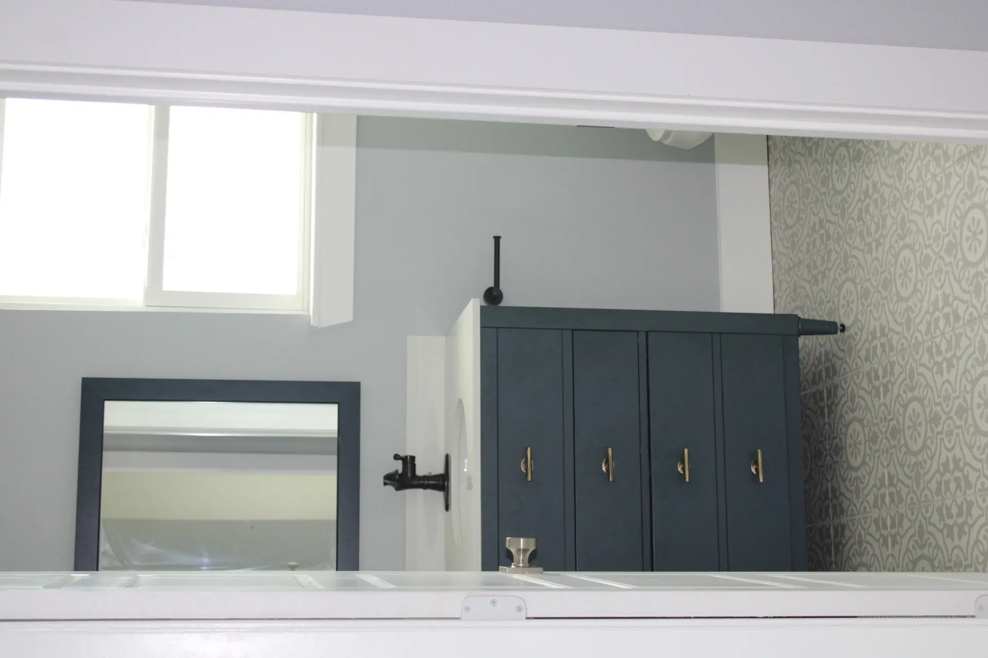 Open-concept living area with white walls, dark wood-look plank flooring, recessed lighting, and sliding glass door access to the covered balcony