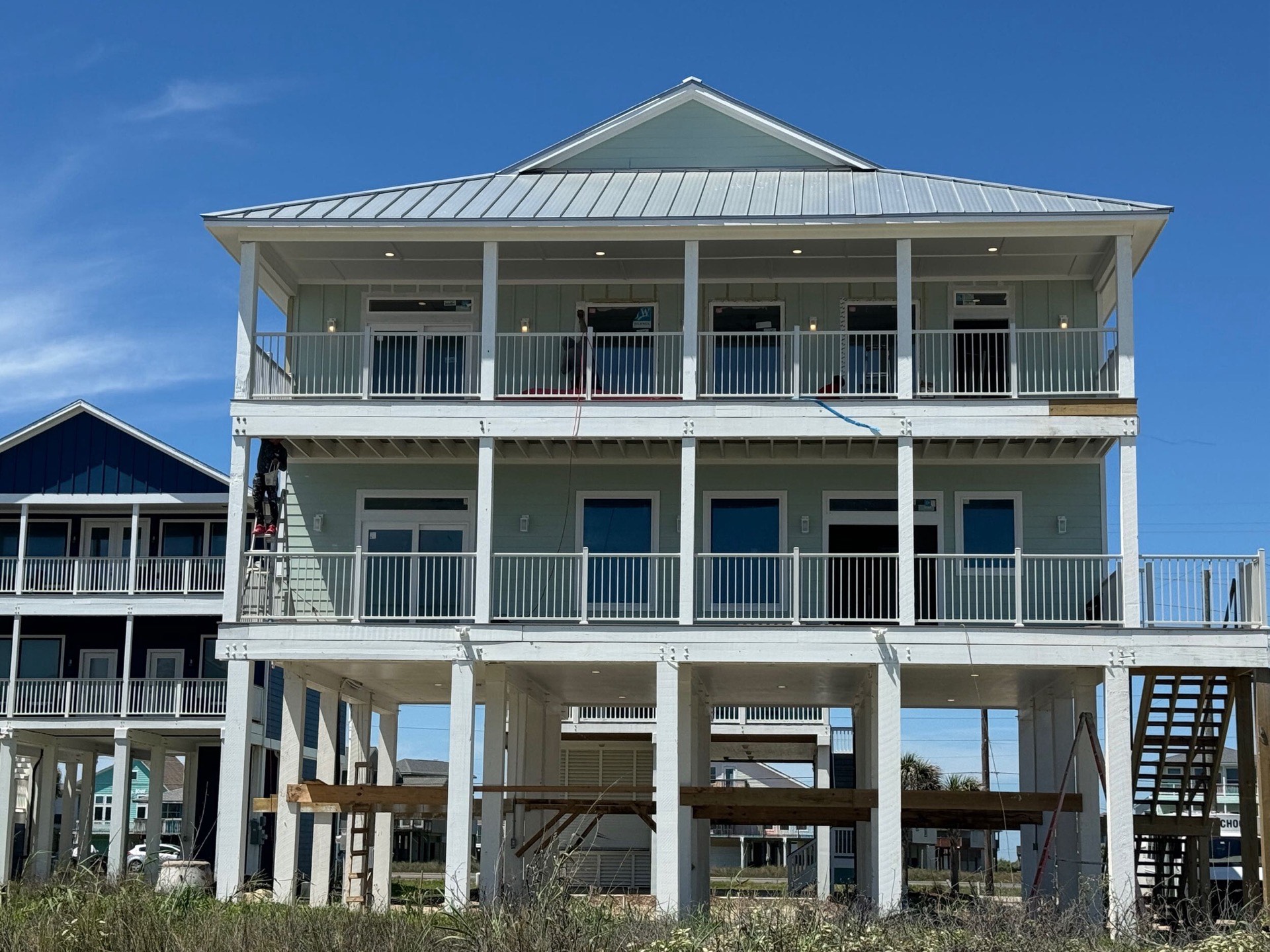 126 Gulf Drive front exterior with two-story wraparound covered porches, standing-seam metal roof, and traditional coastal architecture on Galveston Island