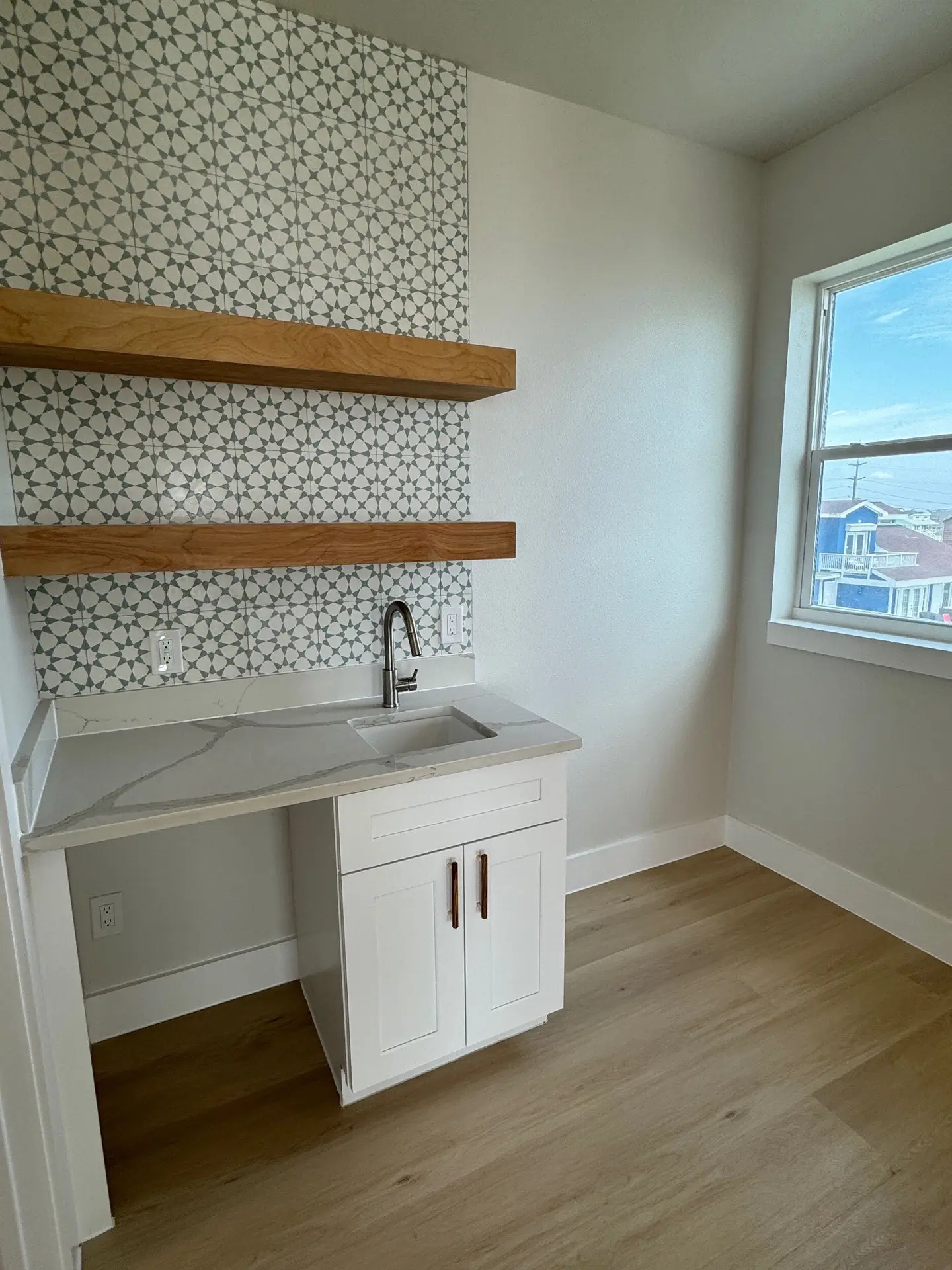 Primary bedroom with light oak hardwood floors, large sliding glass doors opening to a private balcony with Gulf water views