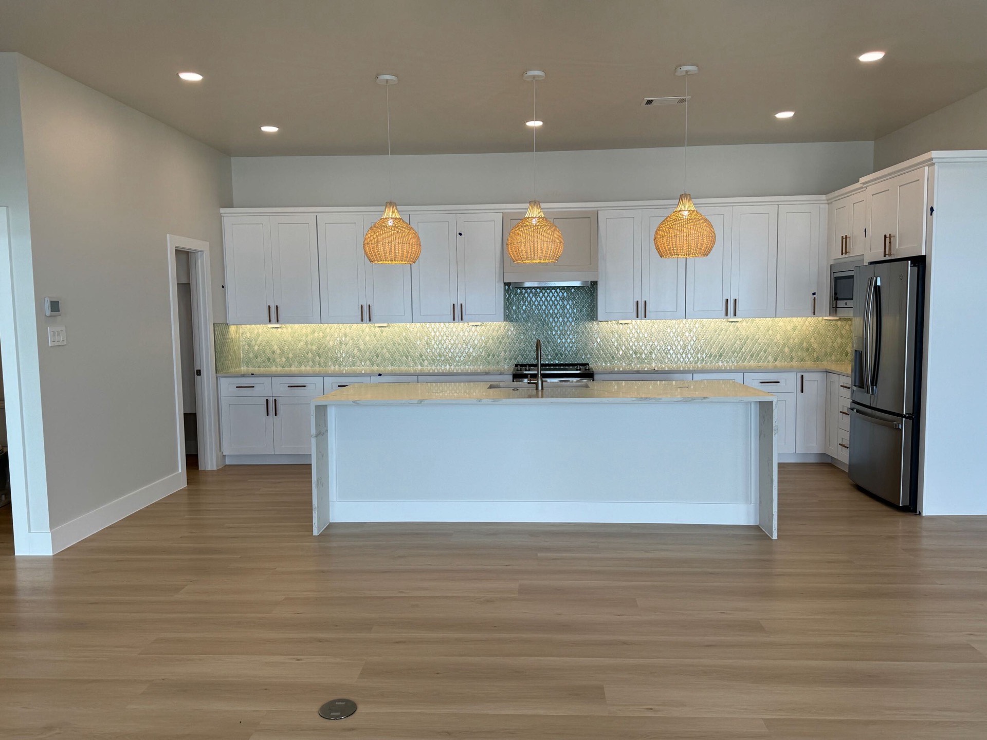 Third bathroom with clean white tile, frameless glass shower, modern brass fixtures, and light neutral color palette