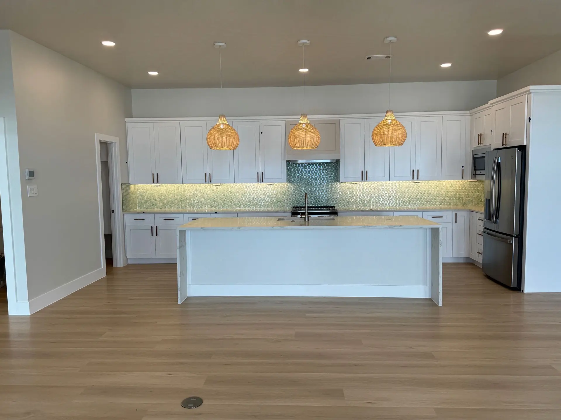Third bathroom with clean white tile, frameless glass shower, modern brass fixtures, and light neutral color palette