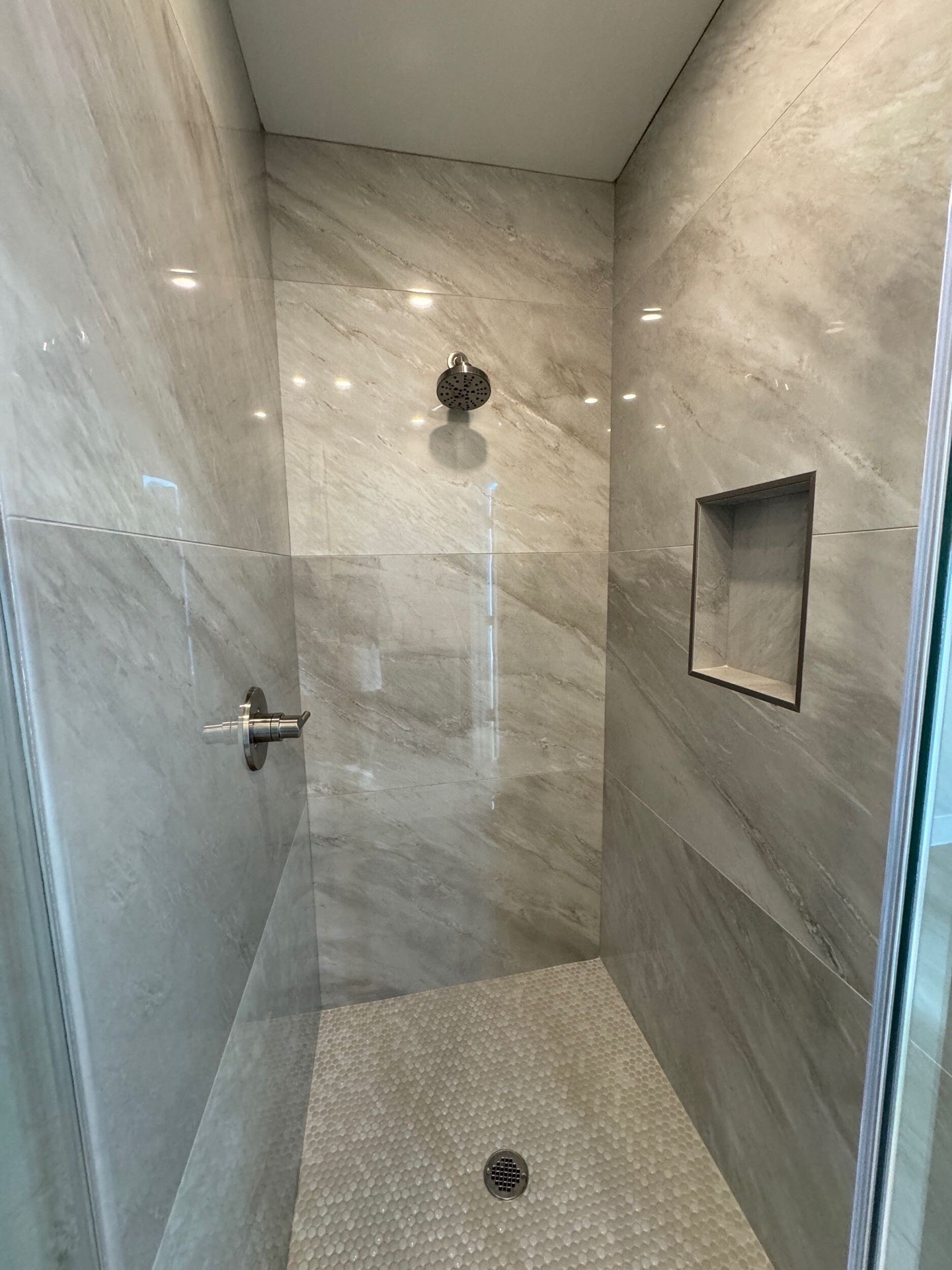 Kitchen island close-up showing white shaker cabinet base with brass pulls and polished countertop under pendant lighting