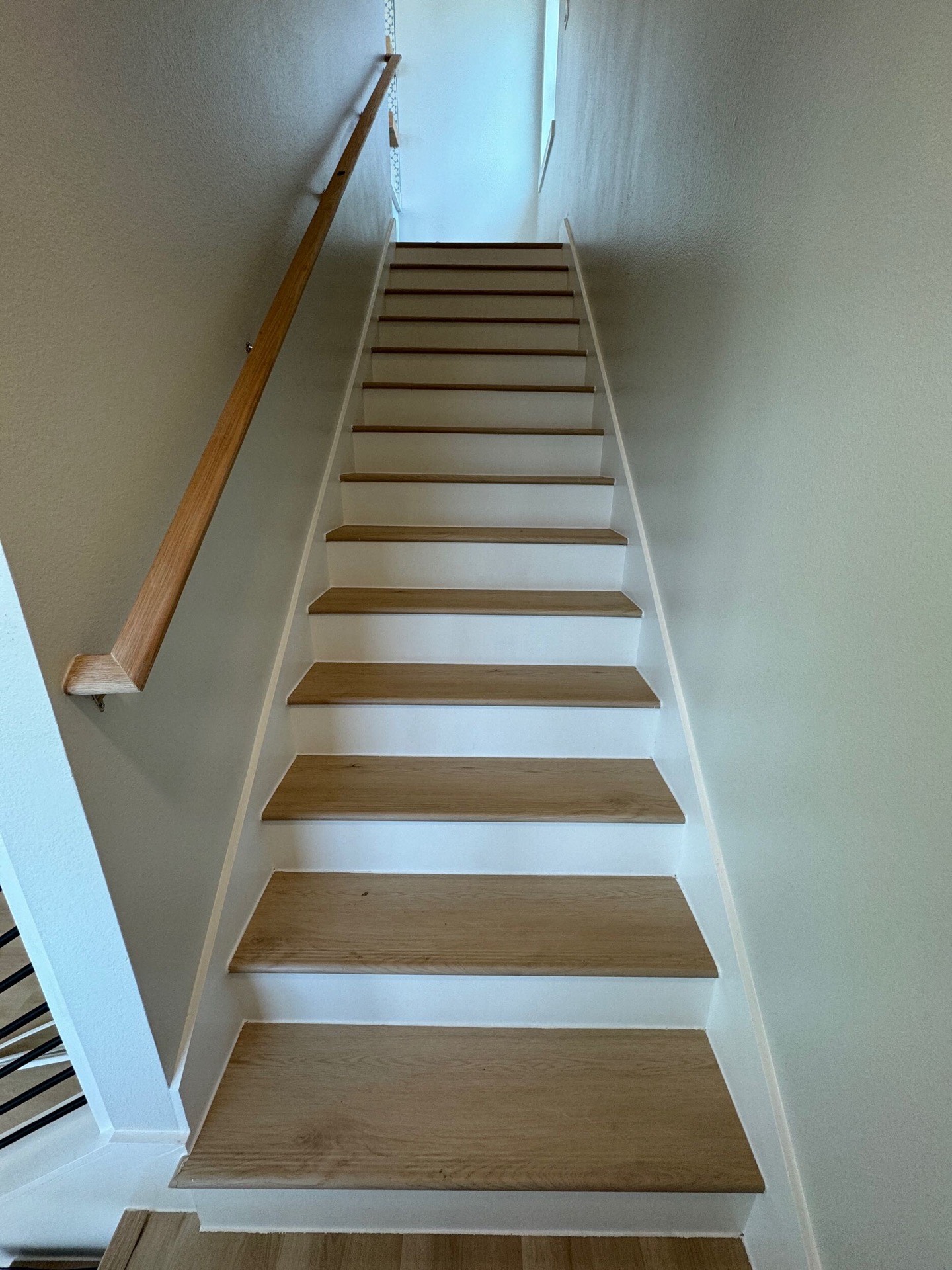Kitchen stovetop wall featuring white subway tile backsplash, brass range hood trim, and integrated spice storage