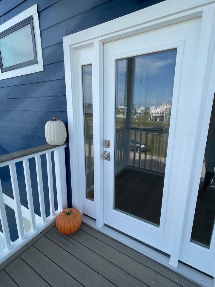 Kitchen pendant lighting over the navy island with white quartz countertops and gold fixture accents throughout the modern coastal kitchen