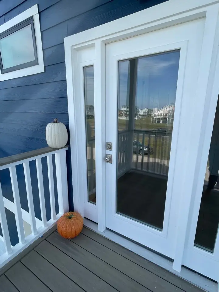 Kitchen pendant lighting over the navy island with white quartz countertops and gold fixture accents throughout the modern coastal kitchen