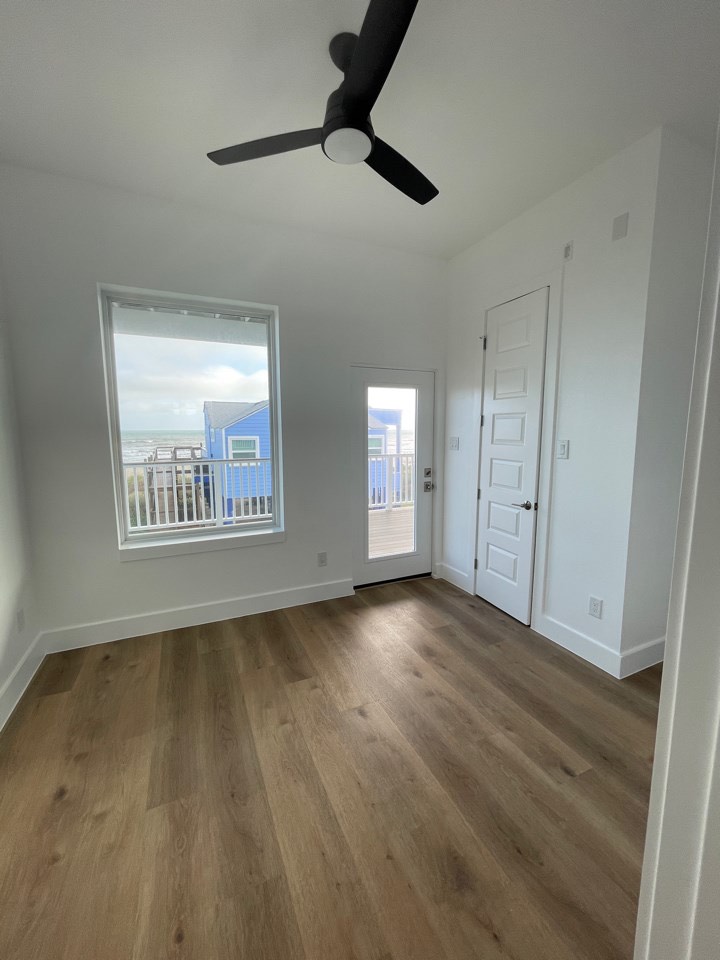 Dining area between the kitchen and living spaces with gulf-facing windows and modern coastal light fixture overhead