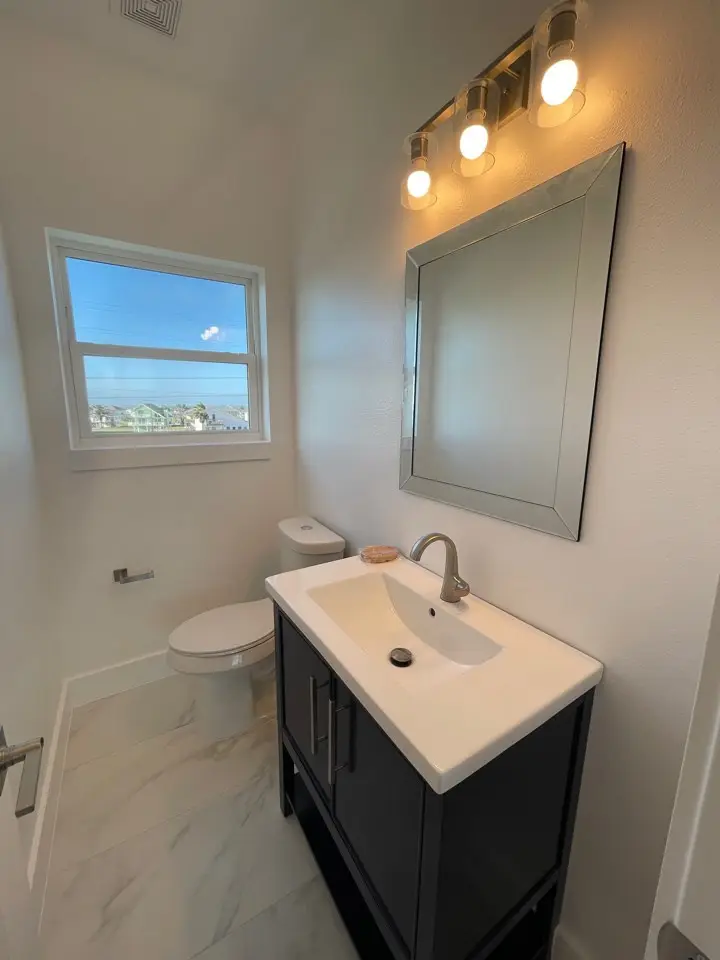 Upper loft overlook railing with black metal balusters looking down into the two-story great room and marble fireplace below