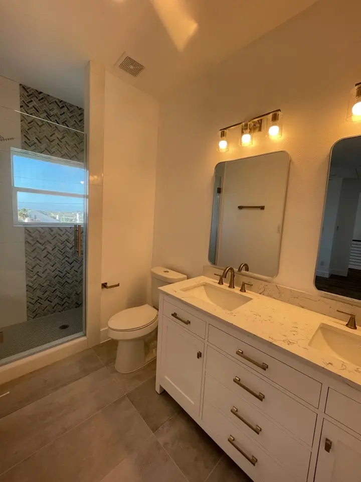 Great room seating area beneath the double-height ceiling with natural light streaming through tall windows on Galveston Island