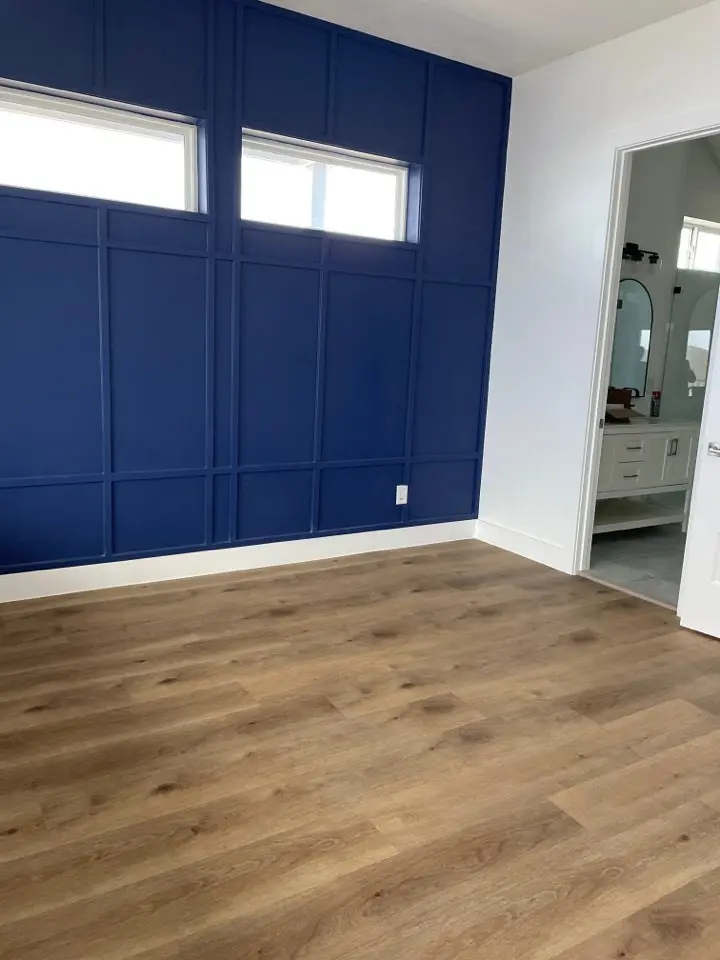 Navy blue double vanity with white marble countertop, dual undermount sinks, and gold wall-mounted mirrors in the master bath