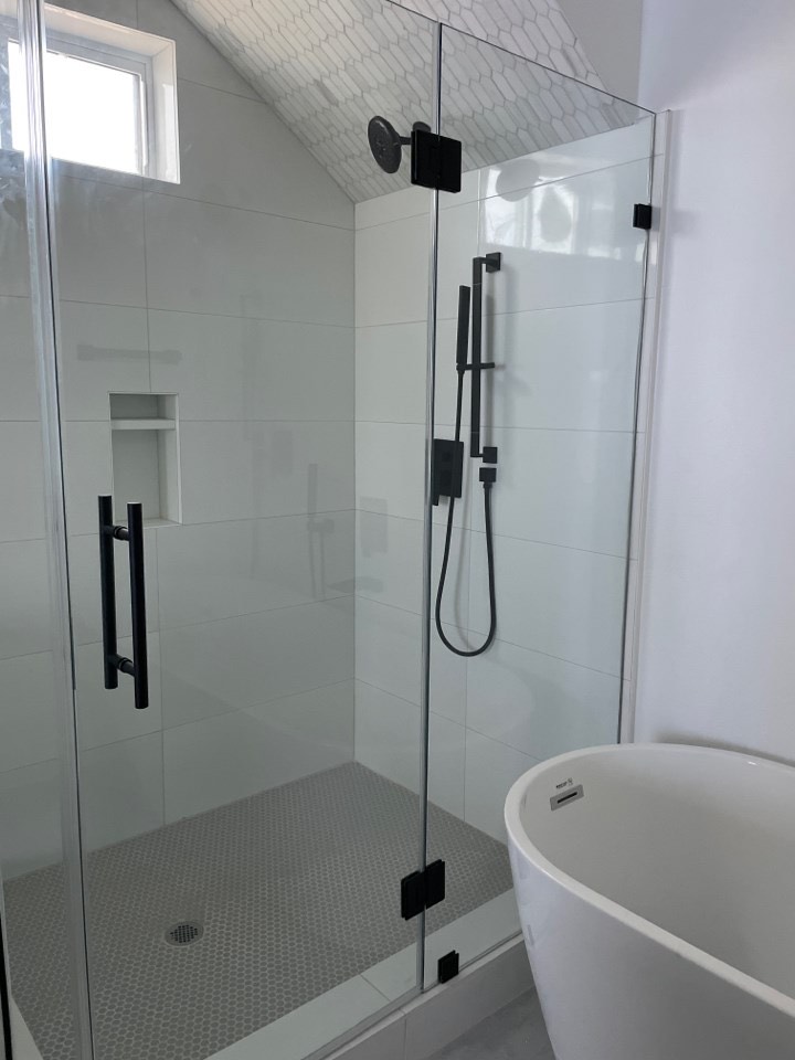 Master bedroom with light oak hardwood floors, large windows with Gulf of Mexico views, and coastal-neutral color palette