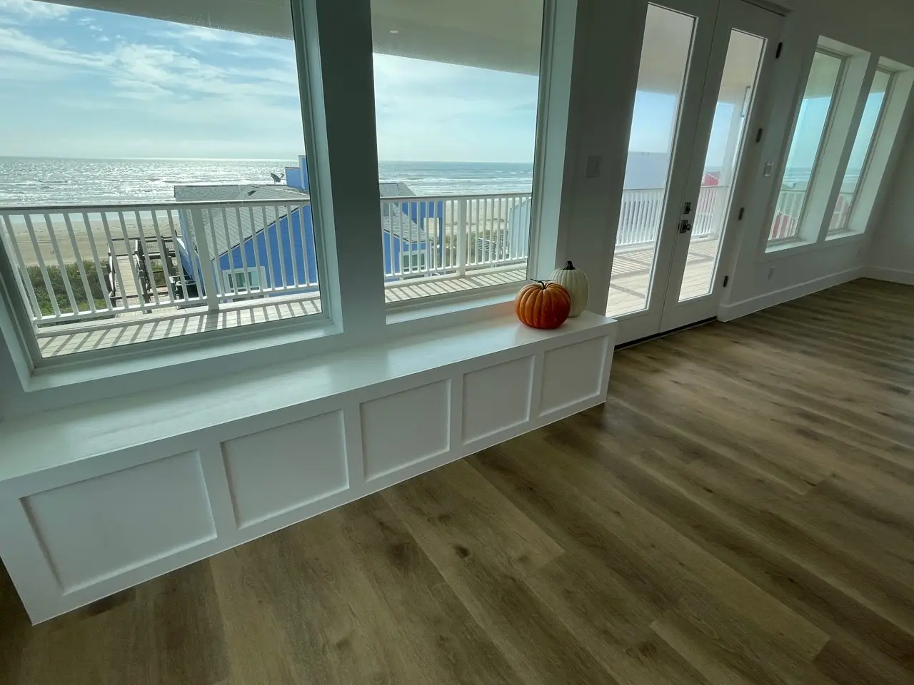 Gourmet kitchen with navy blue center island, white quartz countertops, and custom wood range hood in the open-concept living area of 131 Gulf Drive