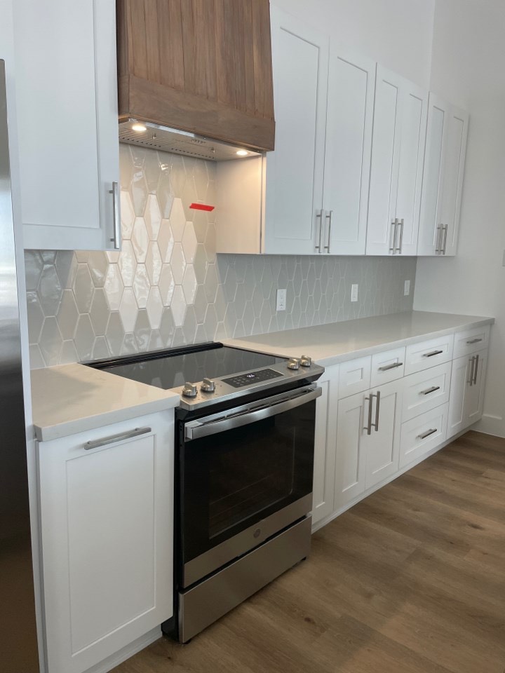 Built-in wine rack and open shelving flanking the kitchen window with Gulf views from the Galveston Island coastal home