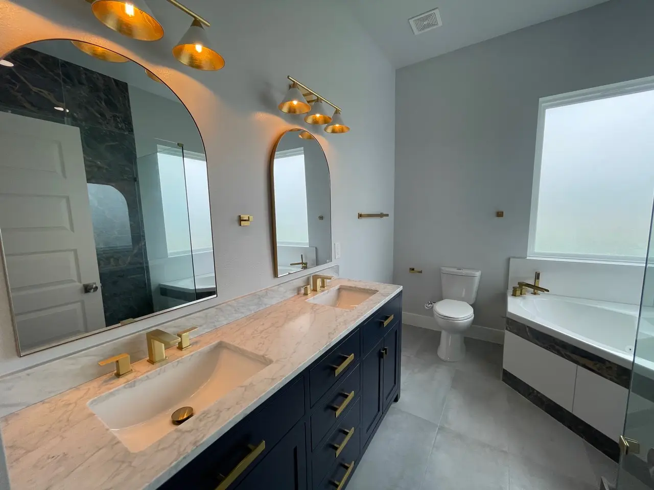 Bedroom with oversized windows on two walls providing panoramic coastal views, light wood flooring, and a bright airy atmosphere