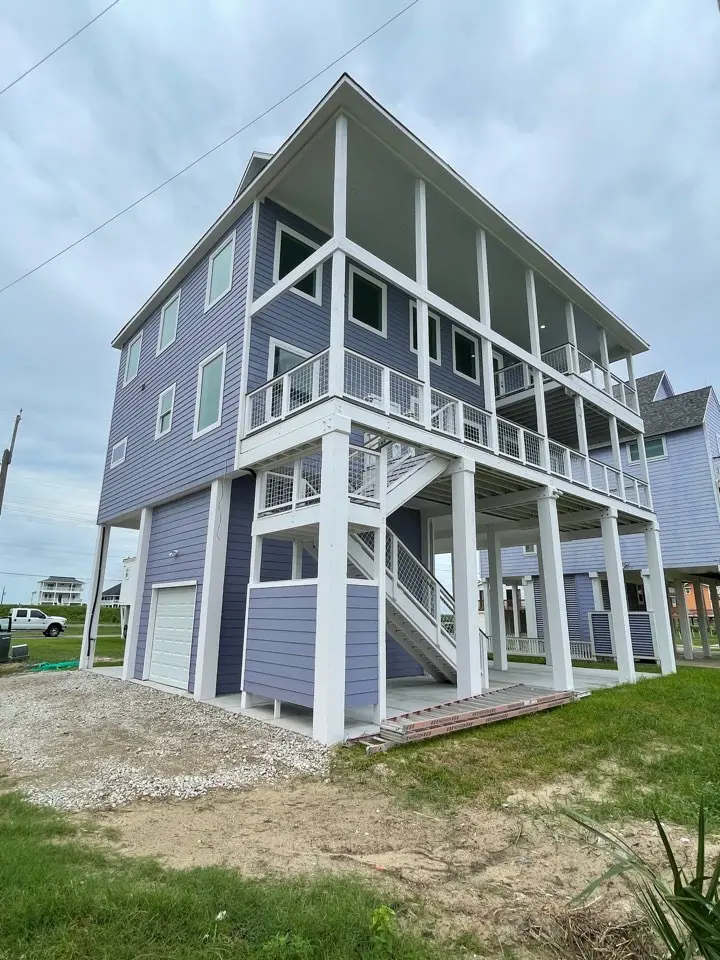 Staircase connecting the main living level to the open mezzanine with light wood treads and modern railing in the Gulf Drive home