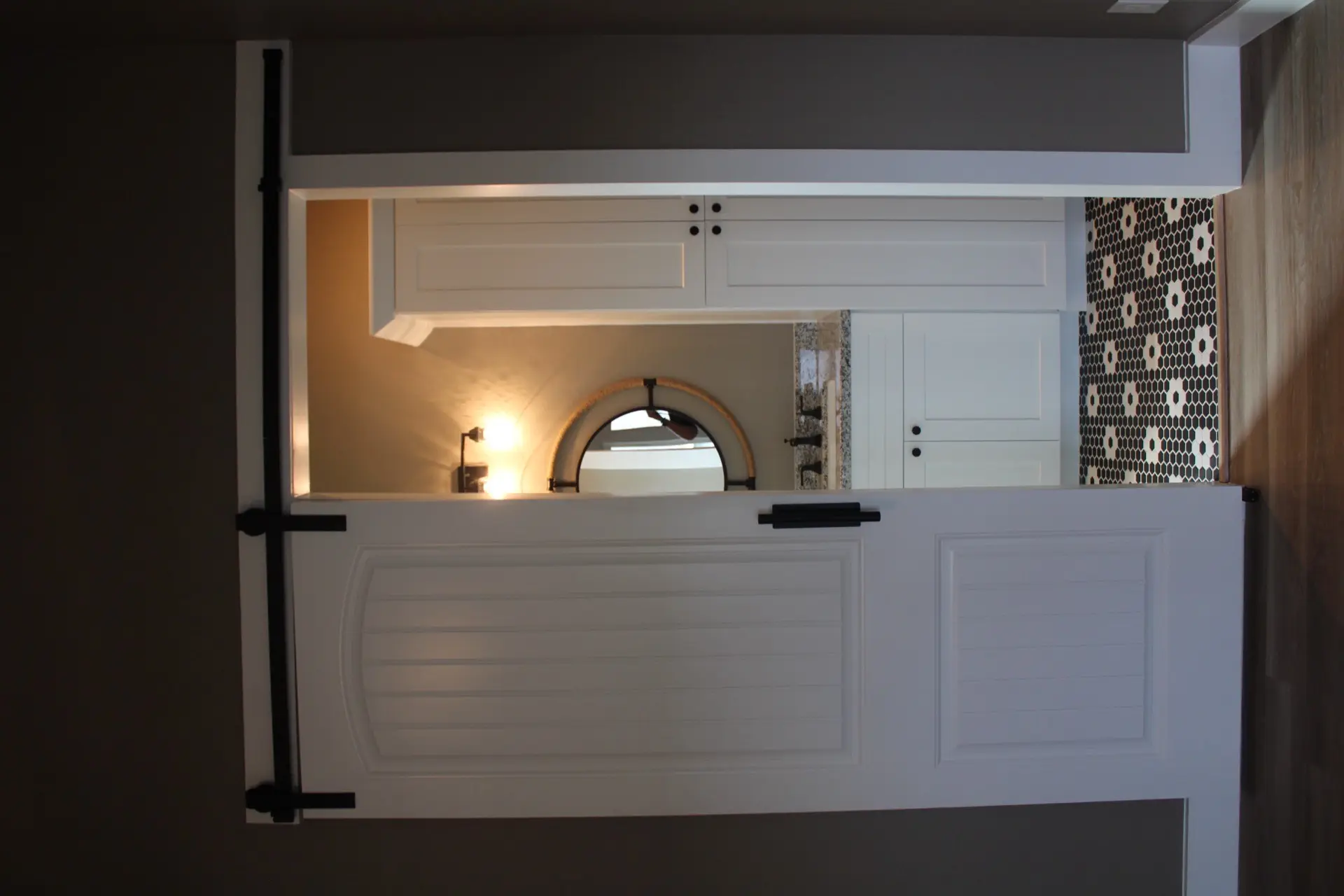 Rear exterior of 27 Laguna with covered deck extending from the master bedroom, white railing, and palm tree-lined backyard on Tiki Island