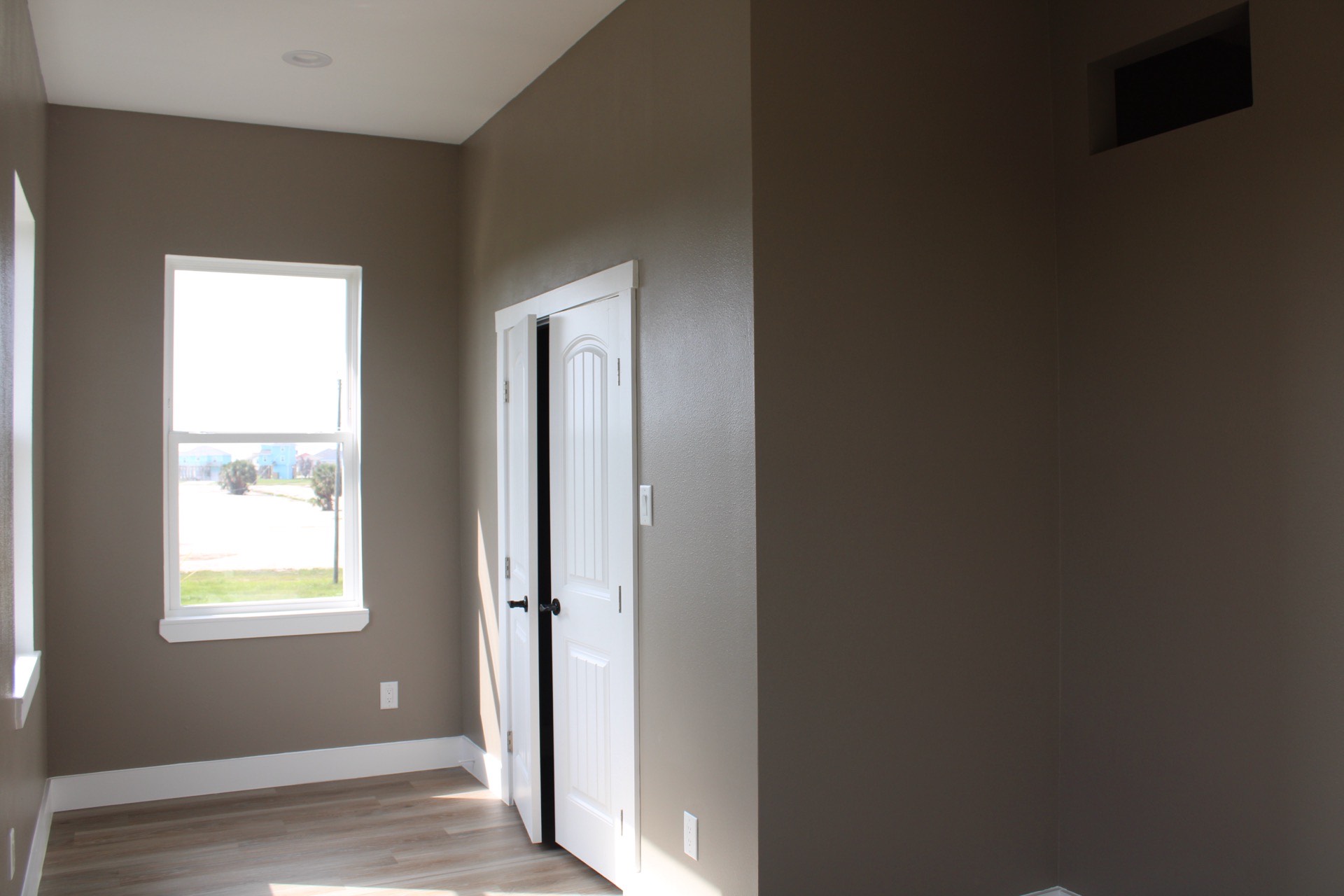 Open-concept kitchen with granite countertops, white shaker cabinets, stone tile backsplash, and pendant lighting over the kitchen island at 27 Laguna