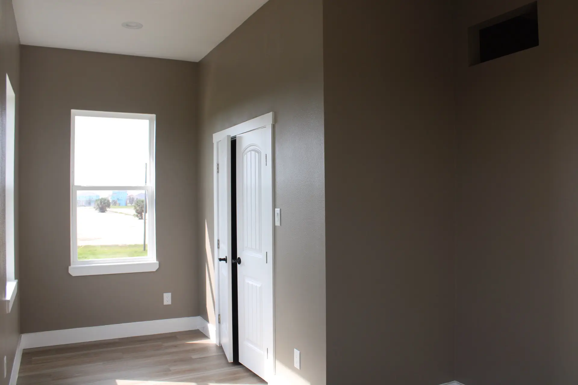 Open-concept kitchen with granite countertops, white shaker cabinets, stone tile backsplash, and pendant lighting over the kitchen island at 27 Laguna