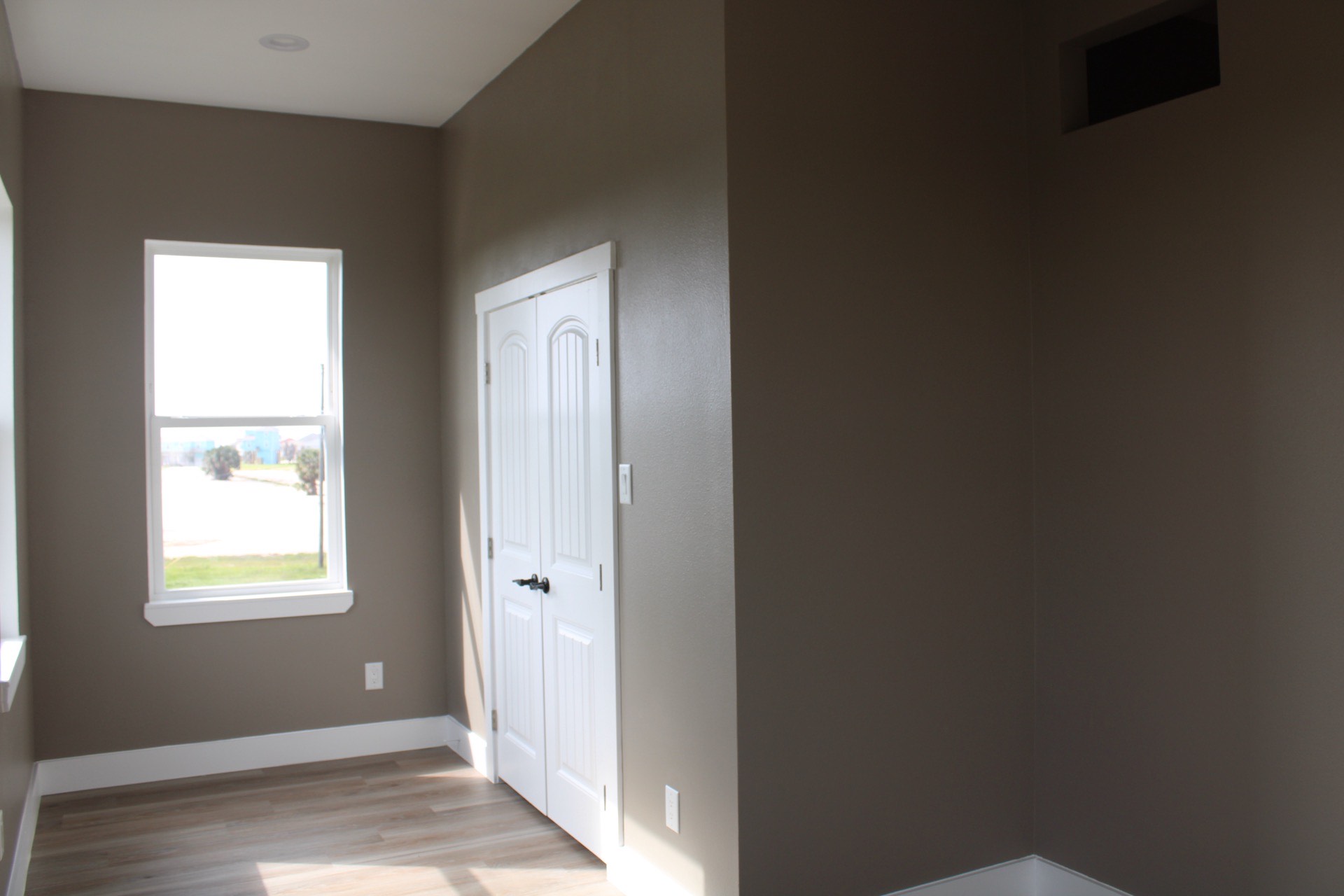 Kitchen island detail showing speckled granite countertop surface, black matte cabinet hardware, and pendant light fixtures above