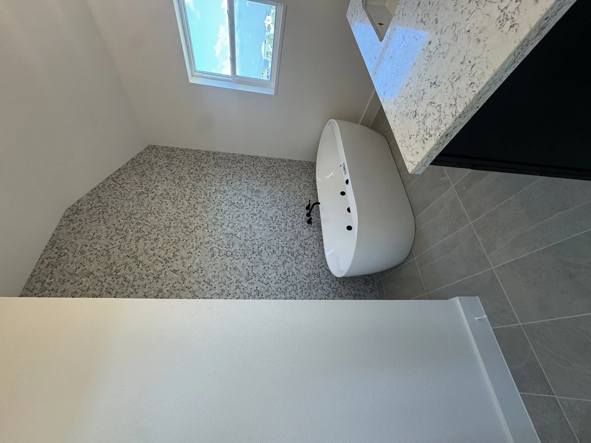 Bathroom vanity area with modern fixtures, clean countertop surface, and the high ceilings characteristic of the 2nd Street coastal home