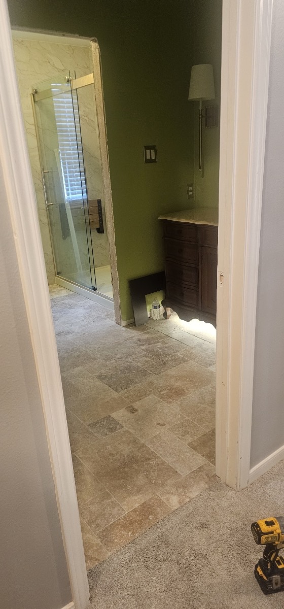 Side angle of the modern coastal home revealing the full two-story porch structure, teal siding, and elevated design on the sandy beachside lot