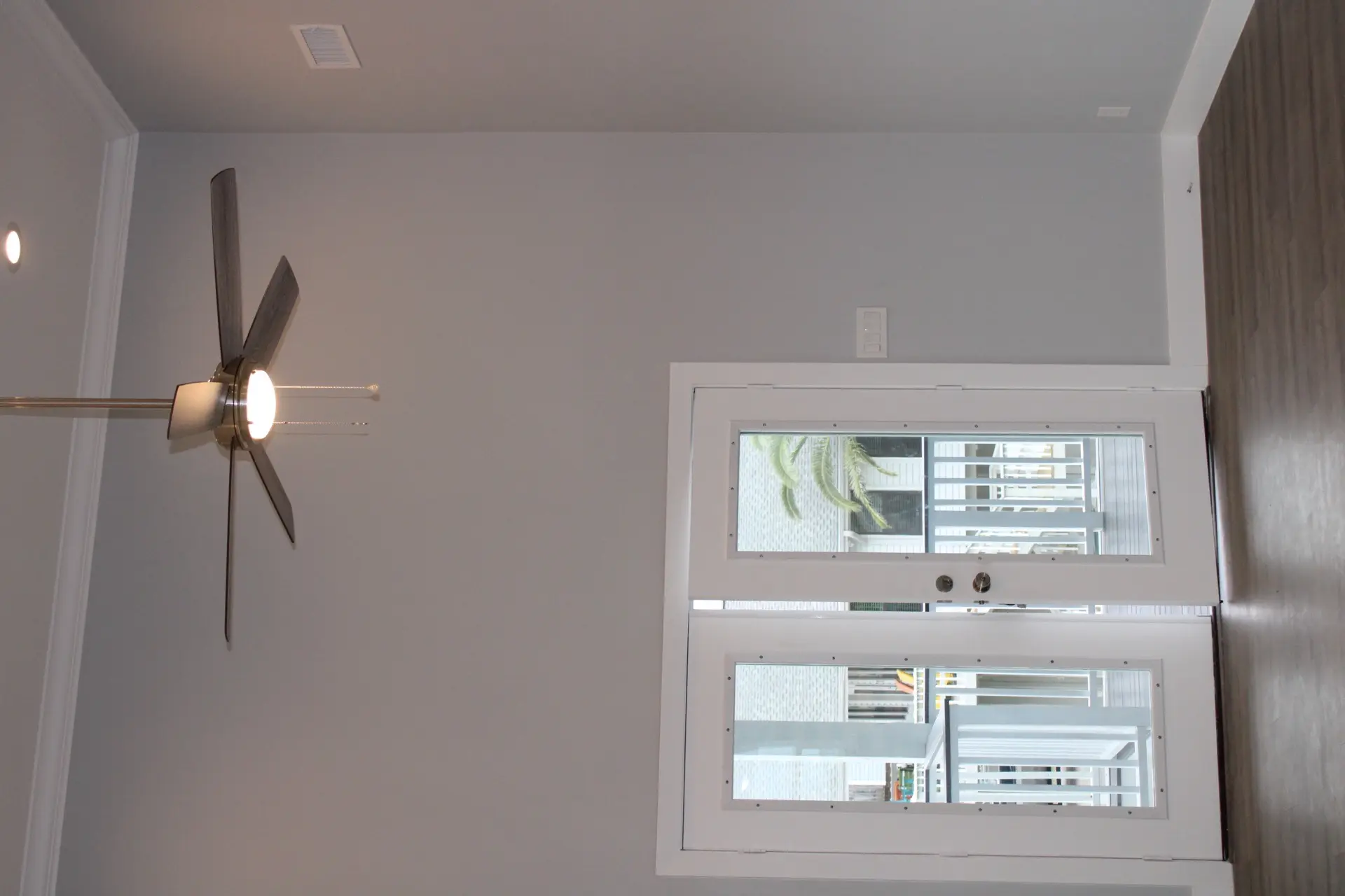 Built-in loft bunk area with wooden ladder, storage drawers beneath the lower bunk, and gray coastal-inspired bedding