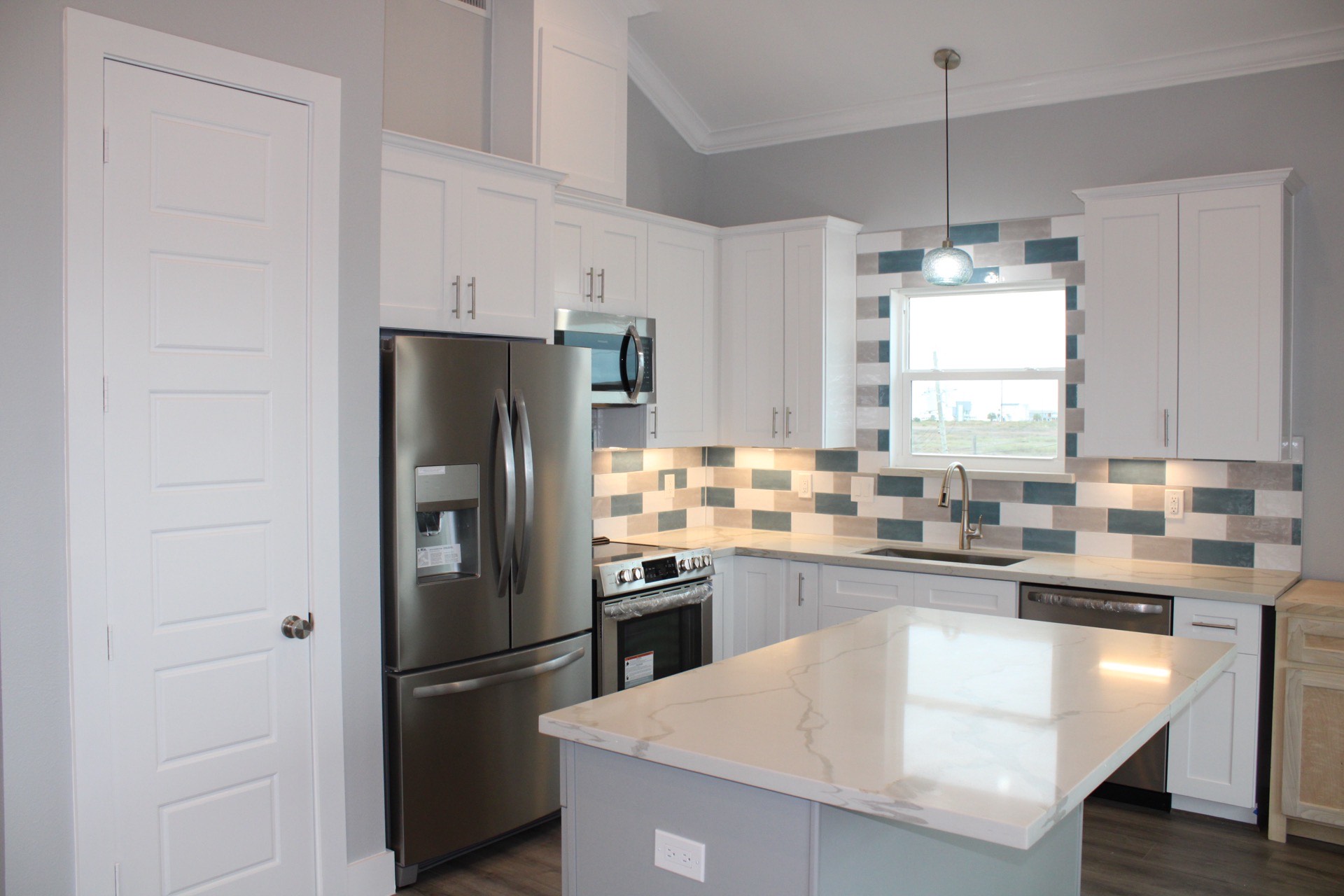 Secondary bedroom with soft blue and gray palette, modern ceiling fan, and ample closet space in the Tiki Island beach house