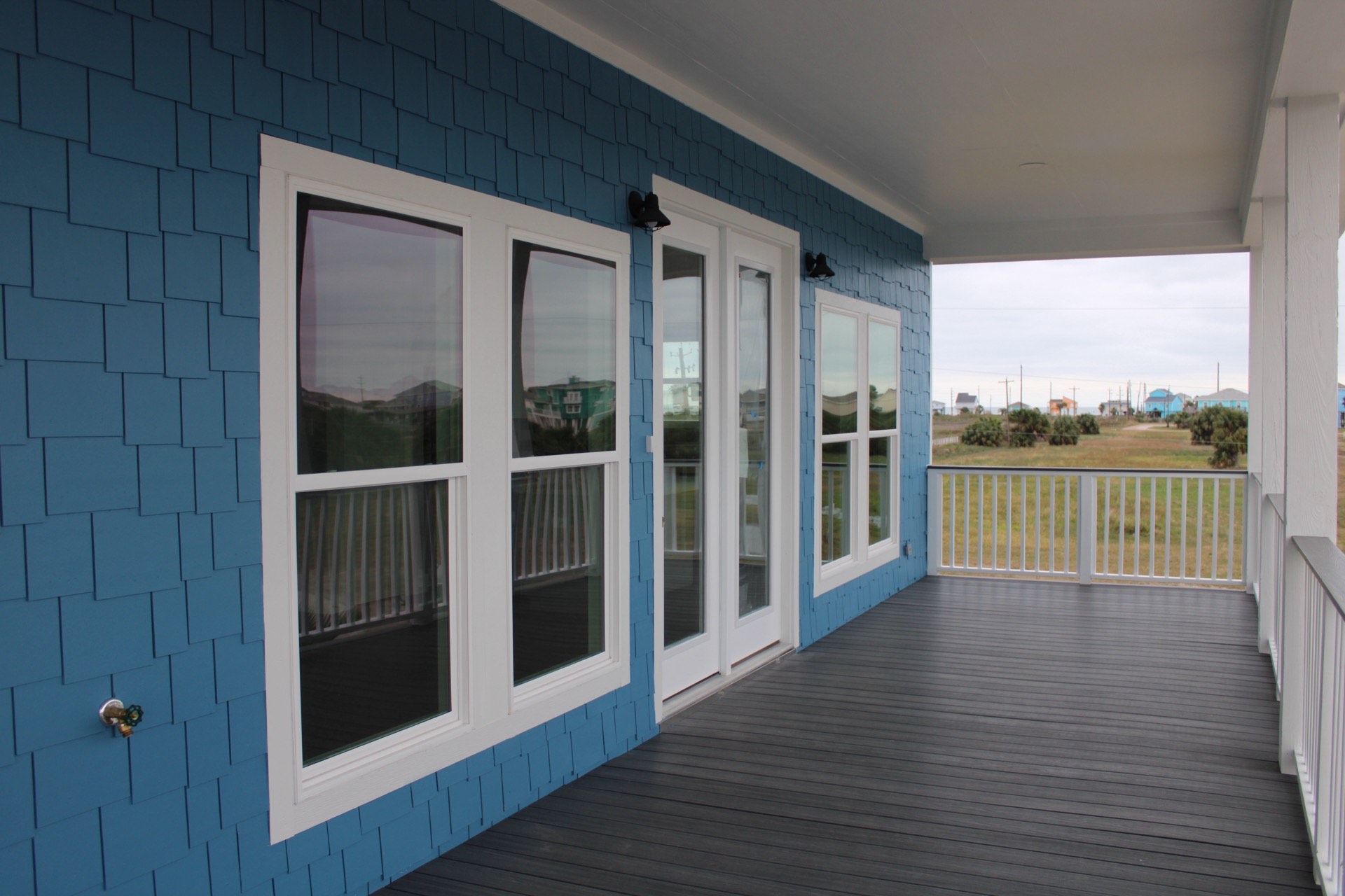 Teal striped tile backsplash detail behind the range, adding bold coastal personality to the white shaker cabinet kitchen