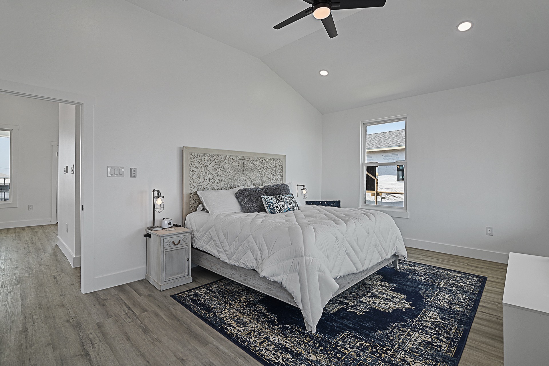 Fireplace detail with shiplap surround, floating wood mantel, and symmetrical built-in shelving with coastal decor accessories