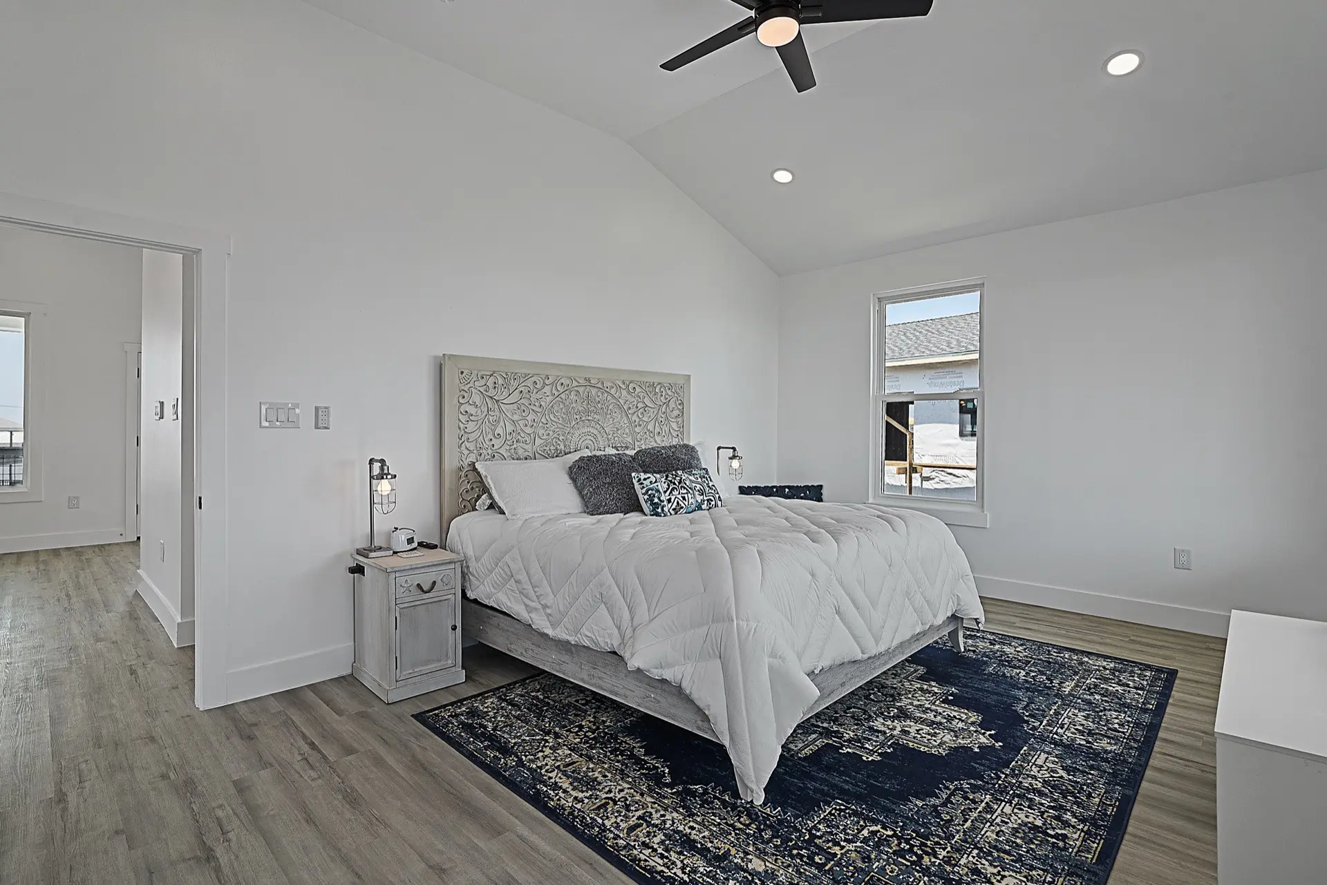 Fireplace detail with shiplap surround, floating wood mantel, and symmetrical built-in shelving with coastal decor accessories