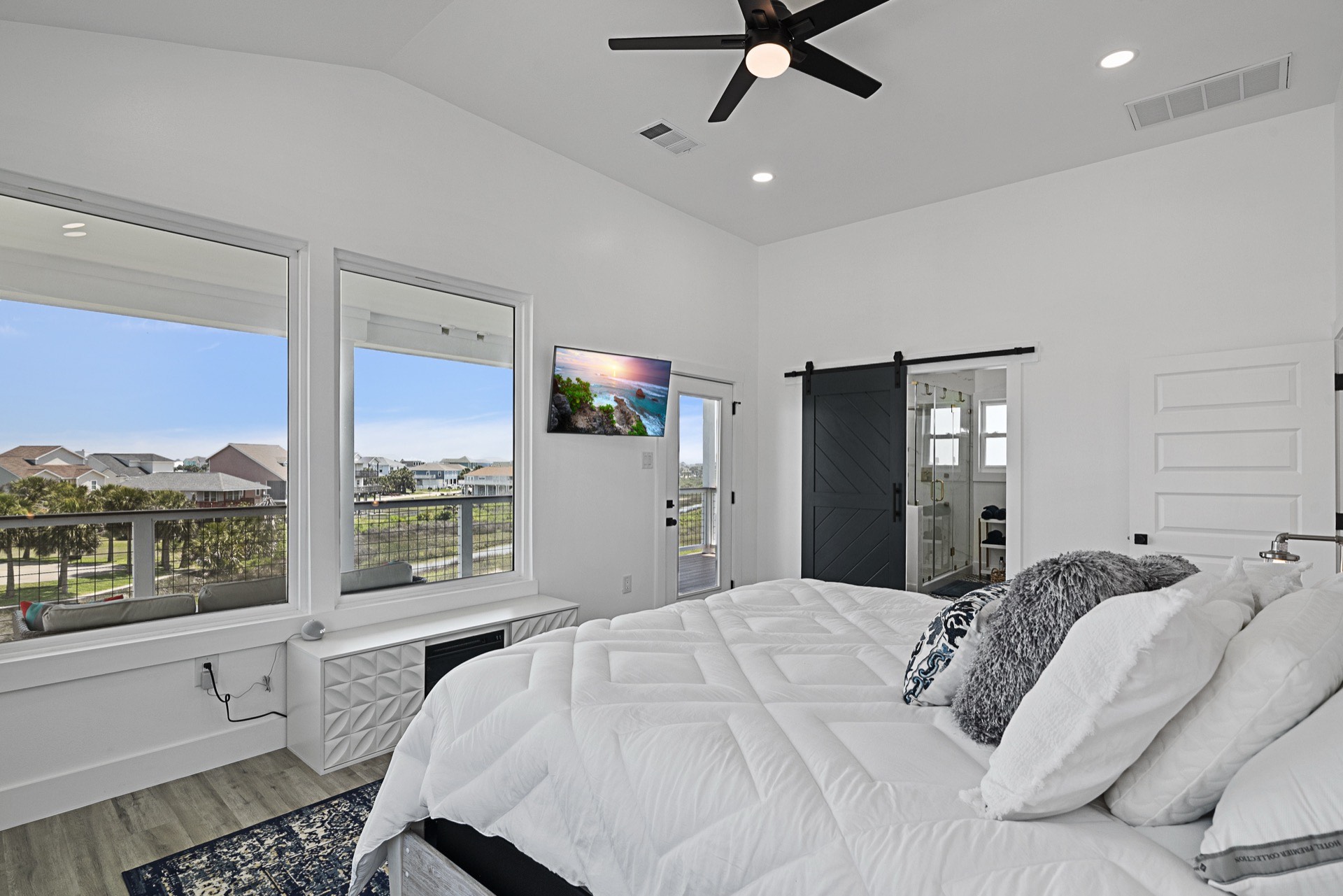 Dining area adjacent to the great room with modern chandelier, staged dining table, and waterfront views from the Tiki Island home