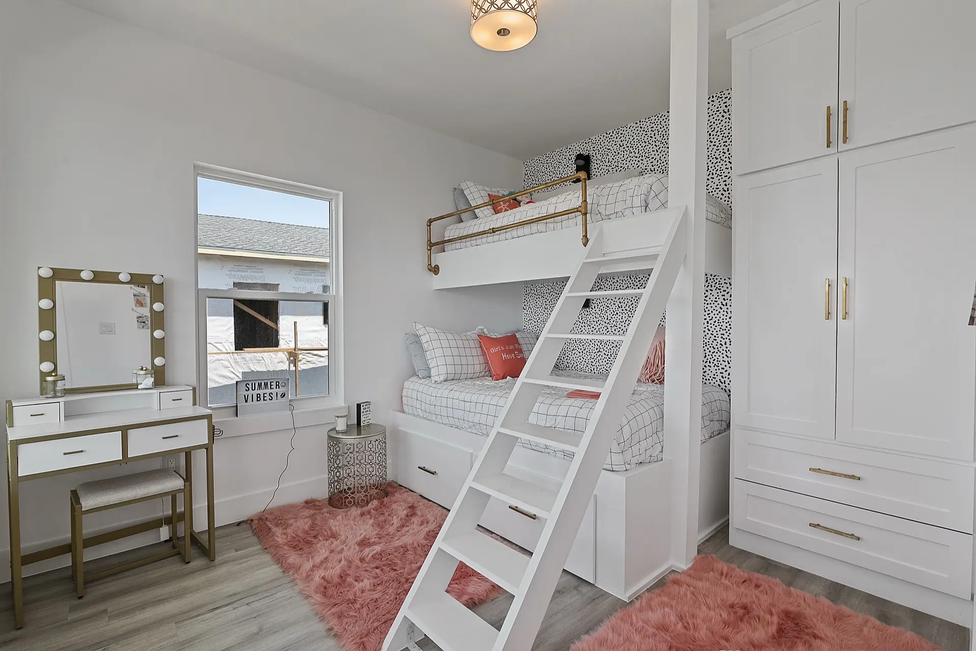 Navy vanity detail with white marble countertop, dual undermount sinks, gold faucets, and decorative geometric floor tile pattern