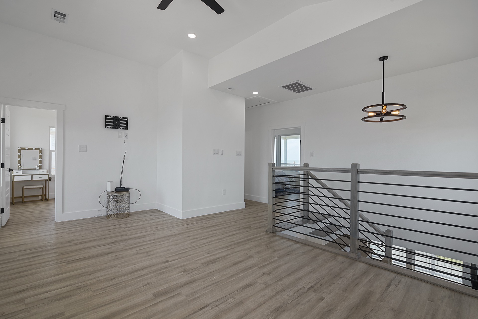 Second guest bedroom with ample natural light, modern ceiling fan, and tasteful coastal furnishings on Tiki Island