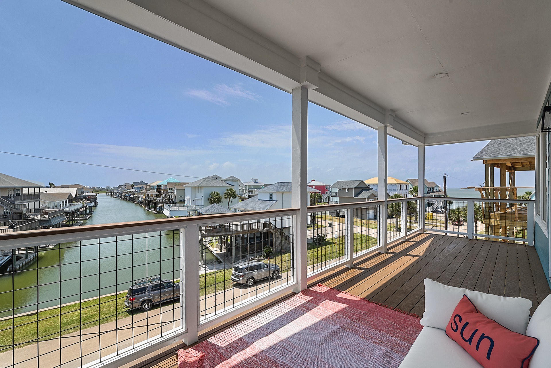 Hall bathroom detail with patterned tile floor, modern vanity lighting, and neutral tile selections complementing the coastal interior