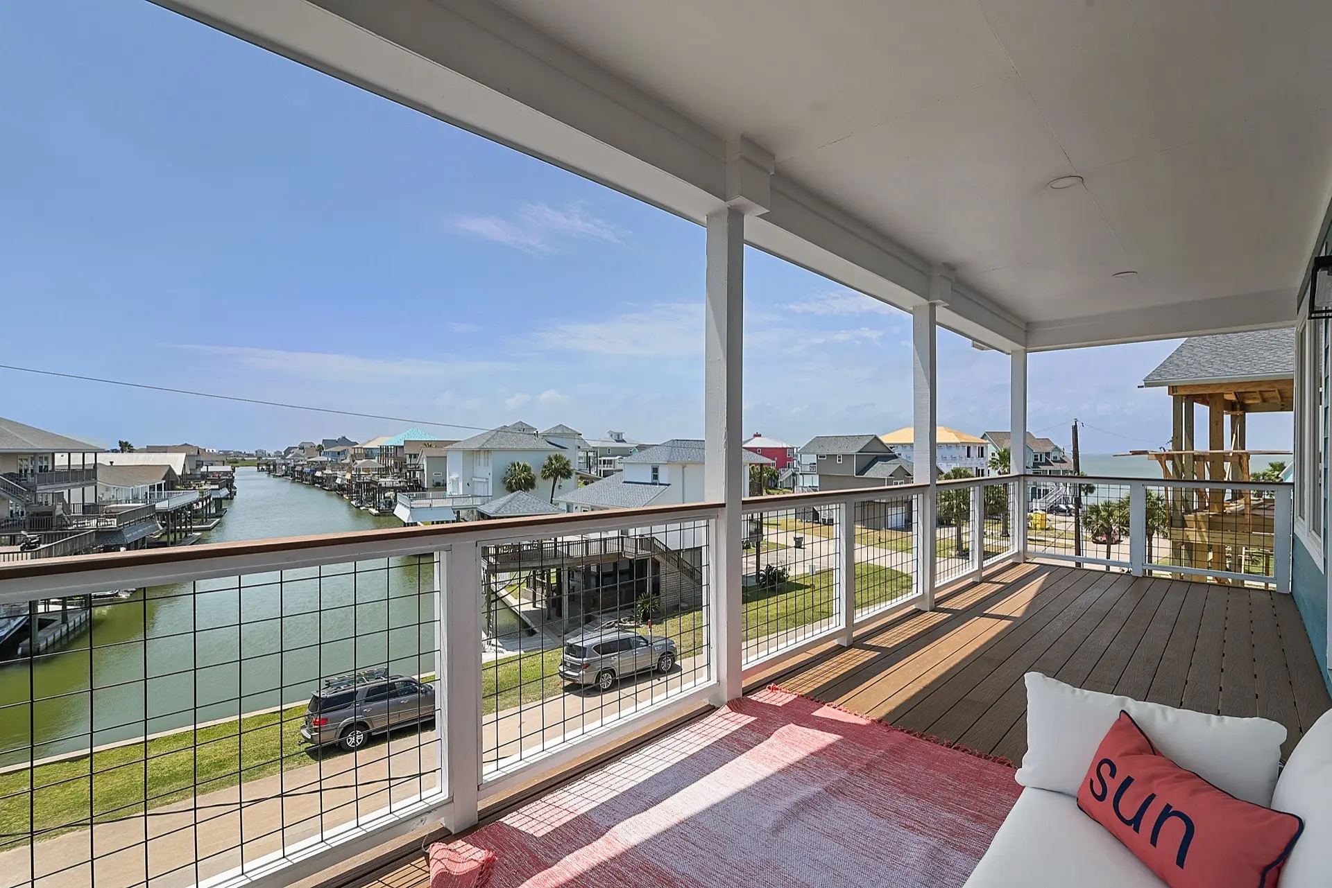 Hall bathroom detail with patterned tile floor, modern vanity lighting, and neutral tile selections complementing the coastal interior