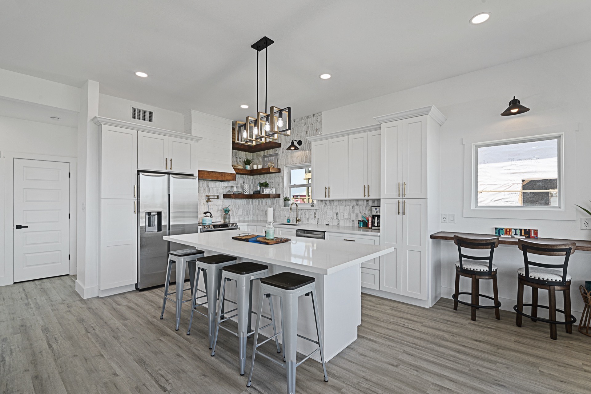 Outdoor dining area on the covered deck with staged furniture, ceiling fan, and unobstructed waterfront views of the Tiki Island canal