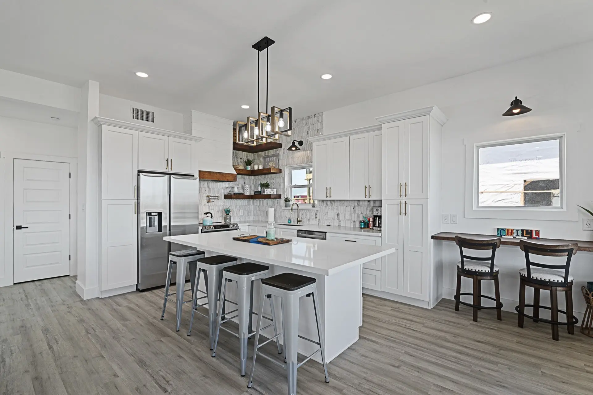 Outdoor dining area on the covered deck with staged furniture, ceiling fan, and unobstructed waterfront views of the Tiki Island canal